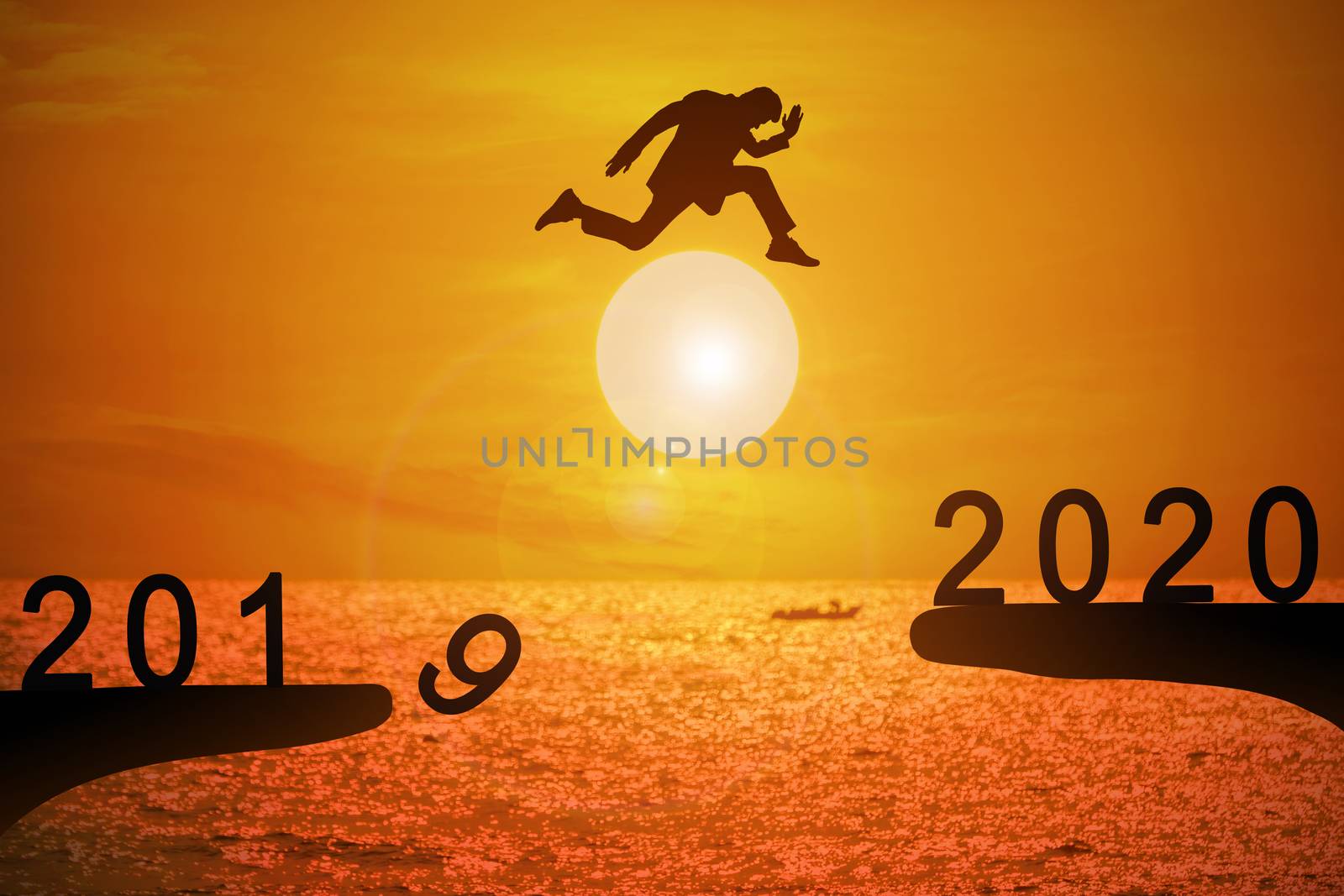 Silhouette of young business mans jumping from the cliff that has the year number 2019 to the side that has the year number 2020 with sun rise at the sea background, Concept for new year target.