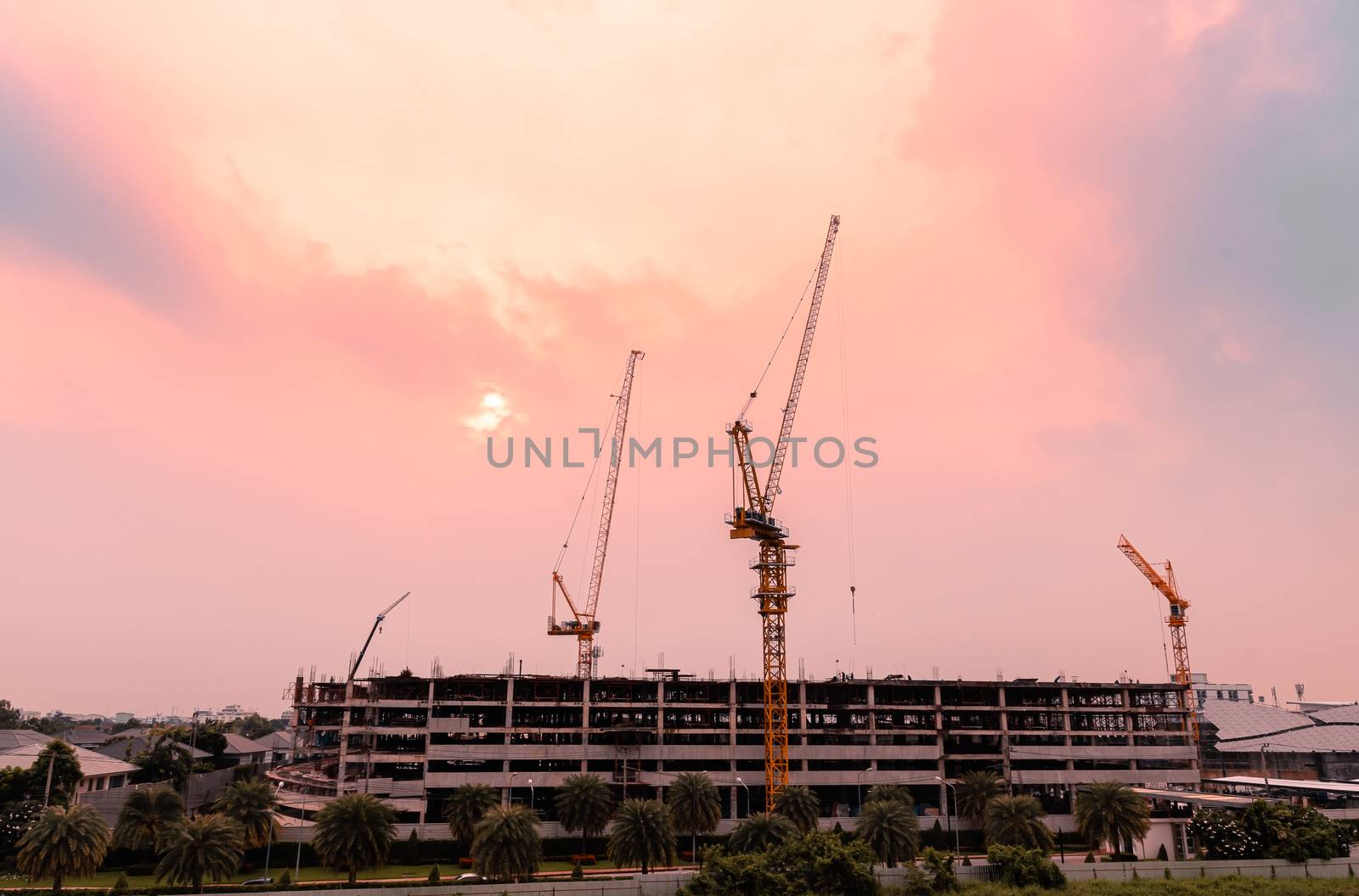 Heavy lifting cranes are important machinery and tools in the construction industry, with beautiful sky in the twilight time.