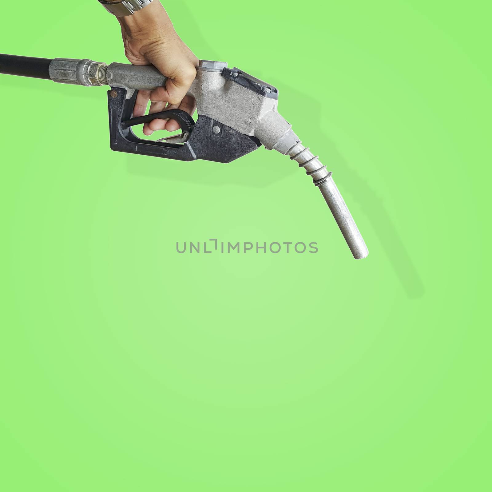 Hand holding a fuel nozzle isolated on beautiful green pastel background with clipping path.
