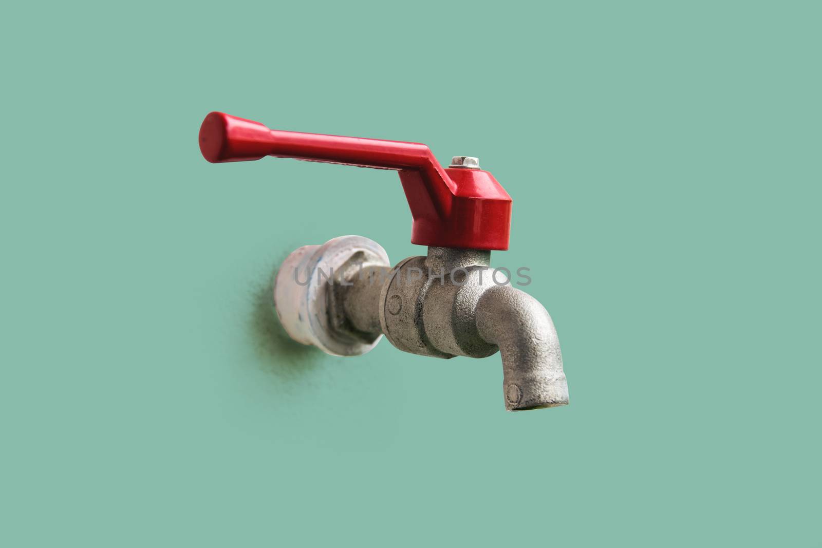 Closeup the tap, red handle that is embedded in the pastel color wall, with clipping path.