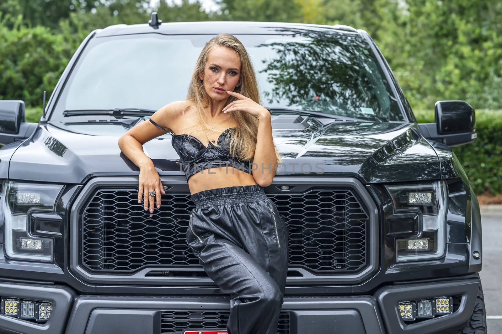 A Lovely Blonde Model Poses Outdoors With Her Black Truck On A Fall Day by actionsports