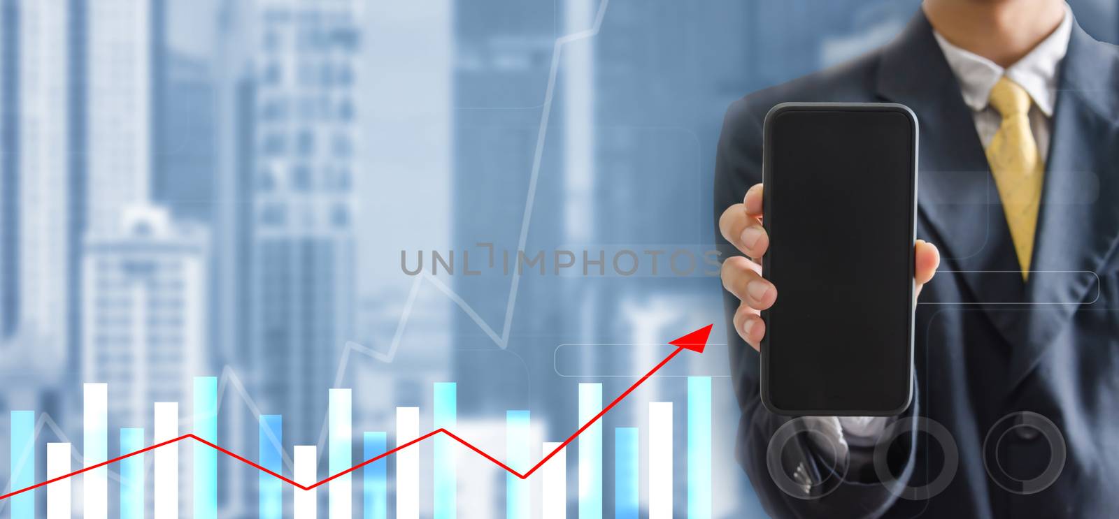 Business concept of digital communication technology.Double exposure hand of a business man in black suit is holding a mobile phone on a cityscape background. Analyze graphs and charts of business growth.Copy space 