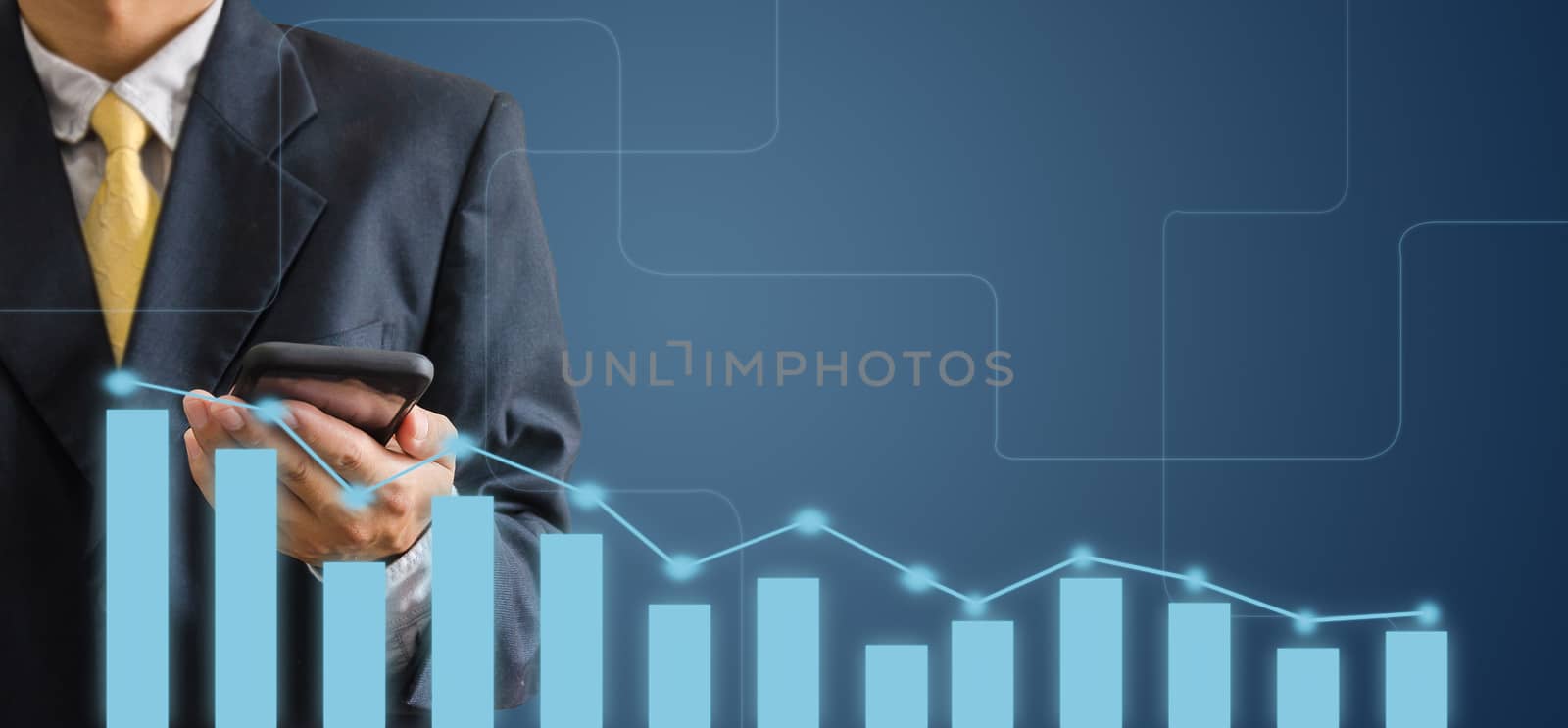 hand of a business man is holding a mobile phone on a gray background. Analyze graphs and charts of business growth.Copy space 