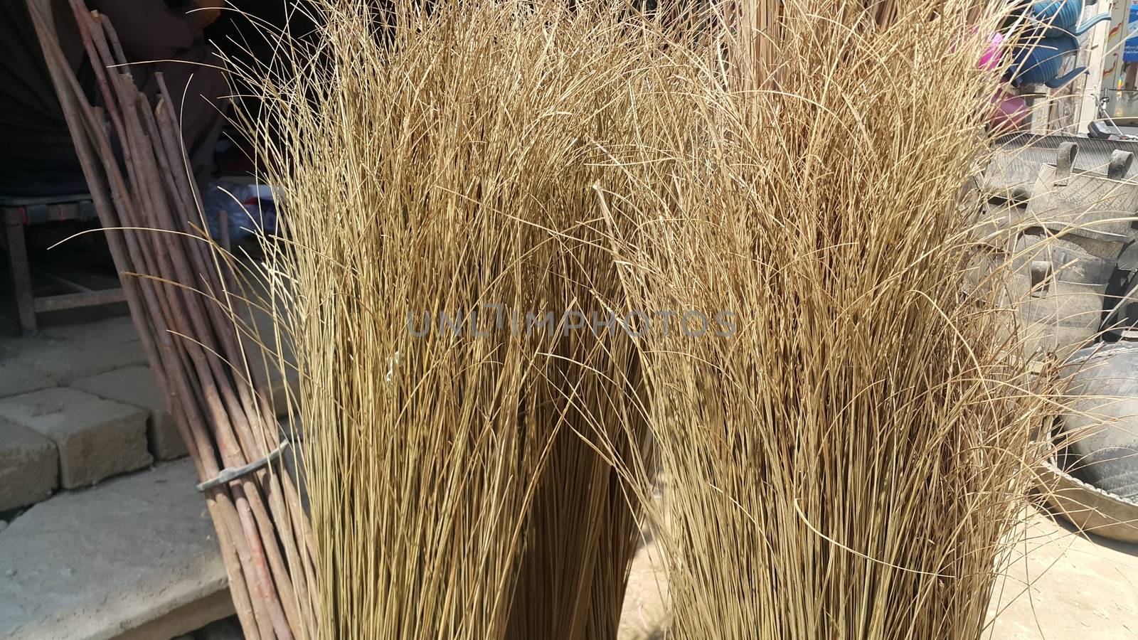 Bunch of brown colored straw broom. Old style broom used for housekeeping in rural area in Asian countries.