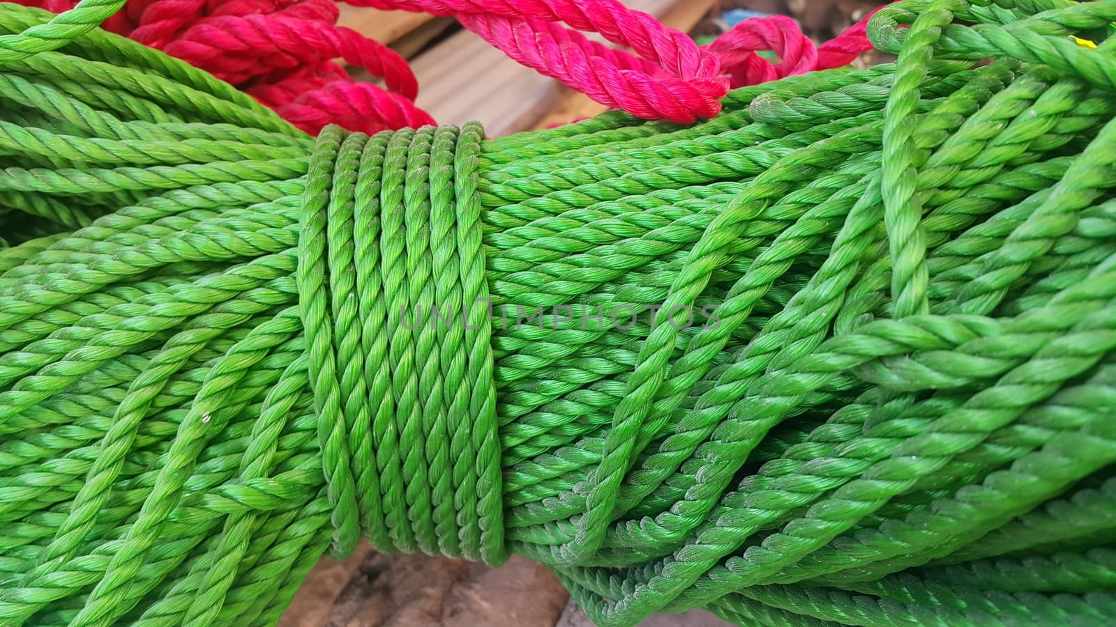 Closeup of bright color braided plastic ropes. Hanks or coil of bright colored plastic rope interwoven which are used for climbing and tightening materials.