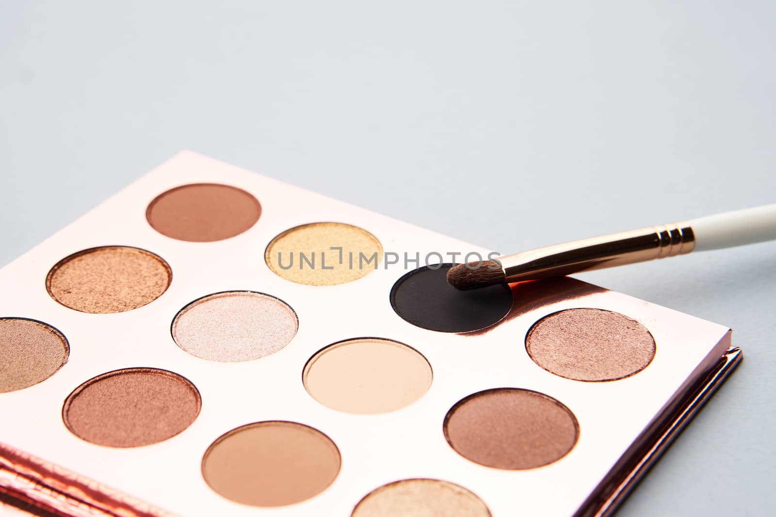 eyeshadow makeup brushes collection professional cosmetics accessories beads on gray background. High quality photo