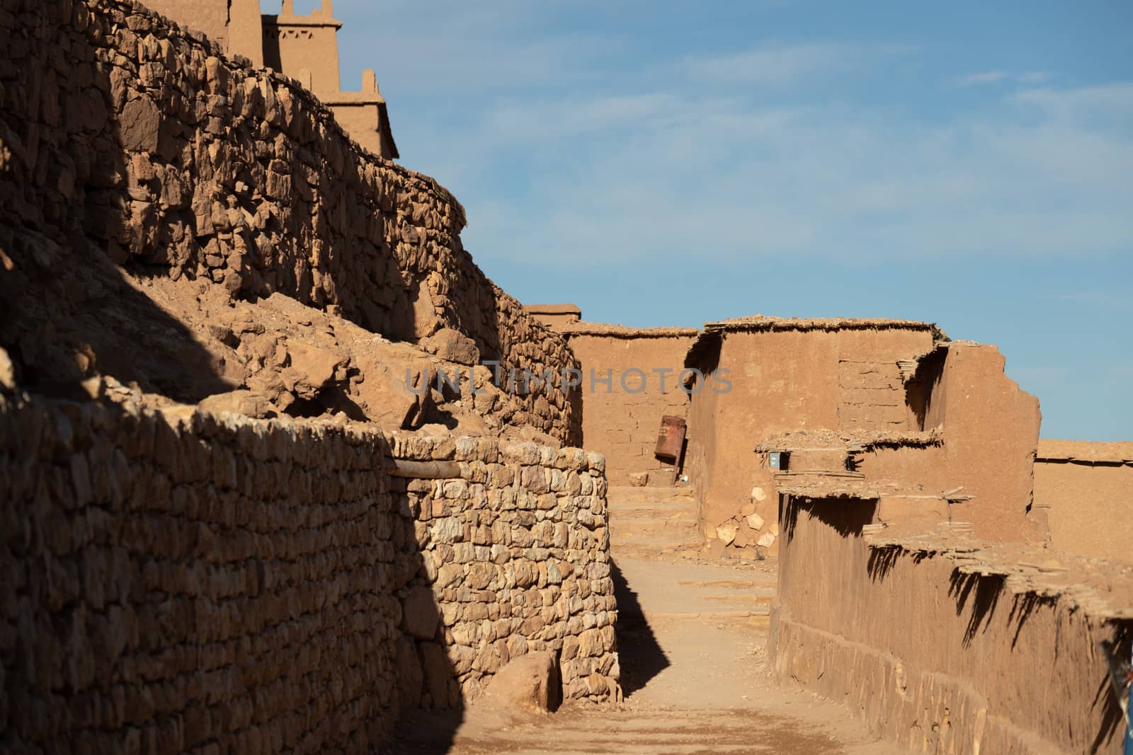 Alleyways in Ait Ben Haddou ksar Morocco, ancient fortress that is a Unesco Heritage site. Beautiful late afternoon light with honey, gold coloured mud brick construction the kasbah, or fortified town dates from 11th cent. and is on the former caravan route from the Sahara and Marrakech. The location has been used for many famous movies. High quality photo