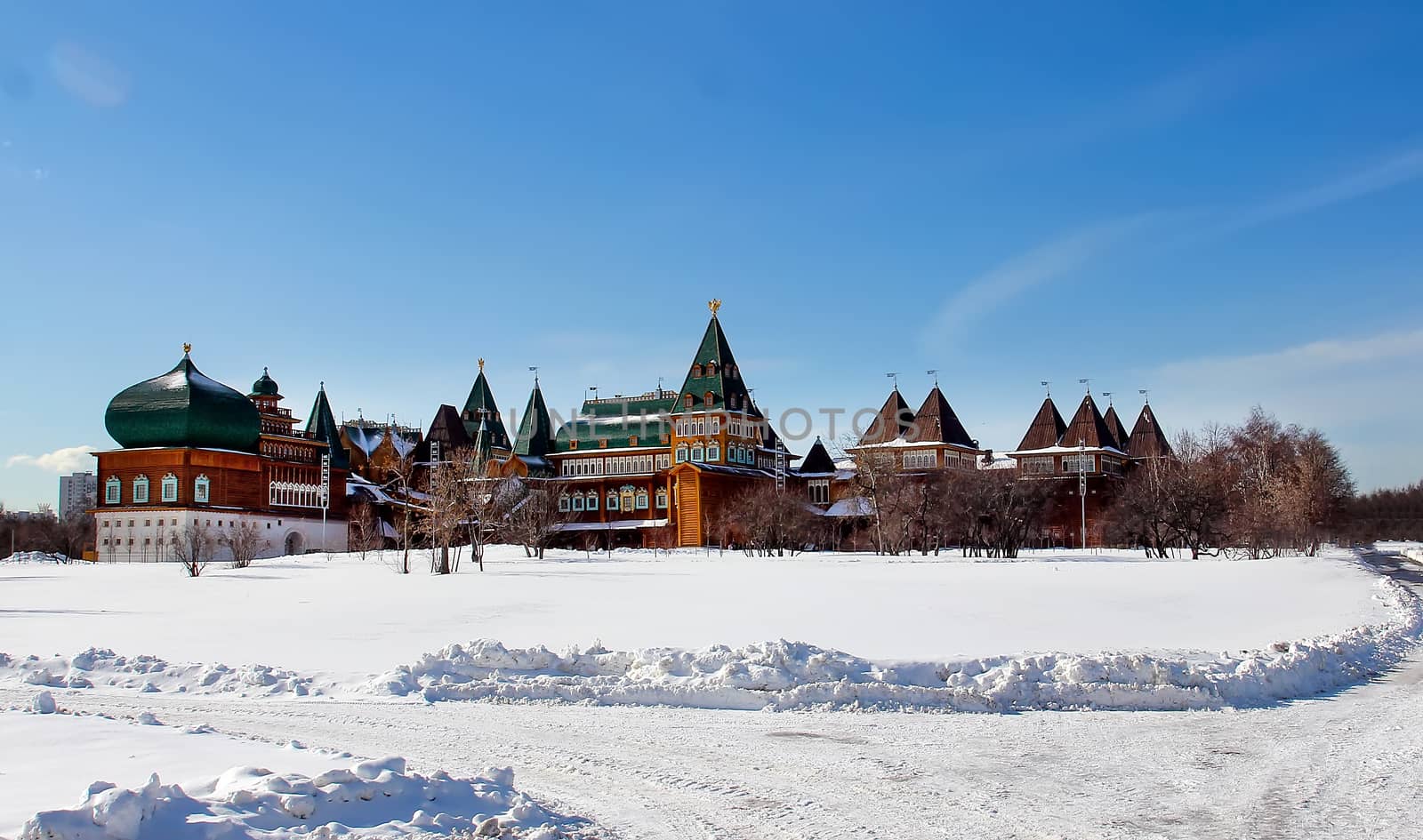Wooden palace in Kolomenskoye. Winter landscape with snow on a background of blue sky with clouds in Kolomenskoye - a palace village, the former royal residence.