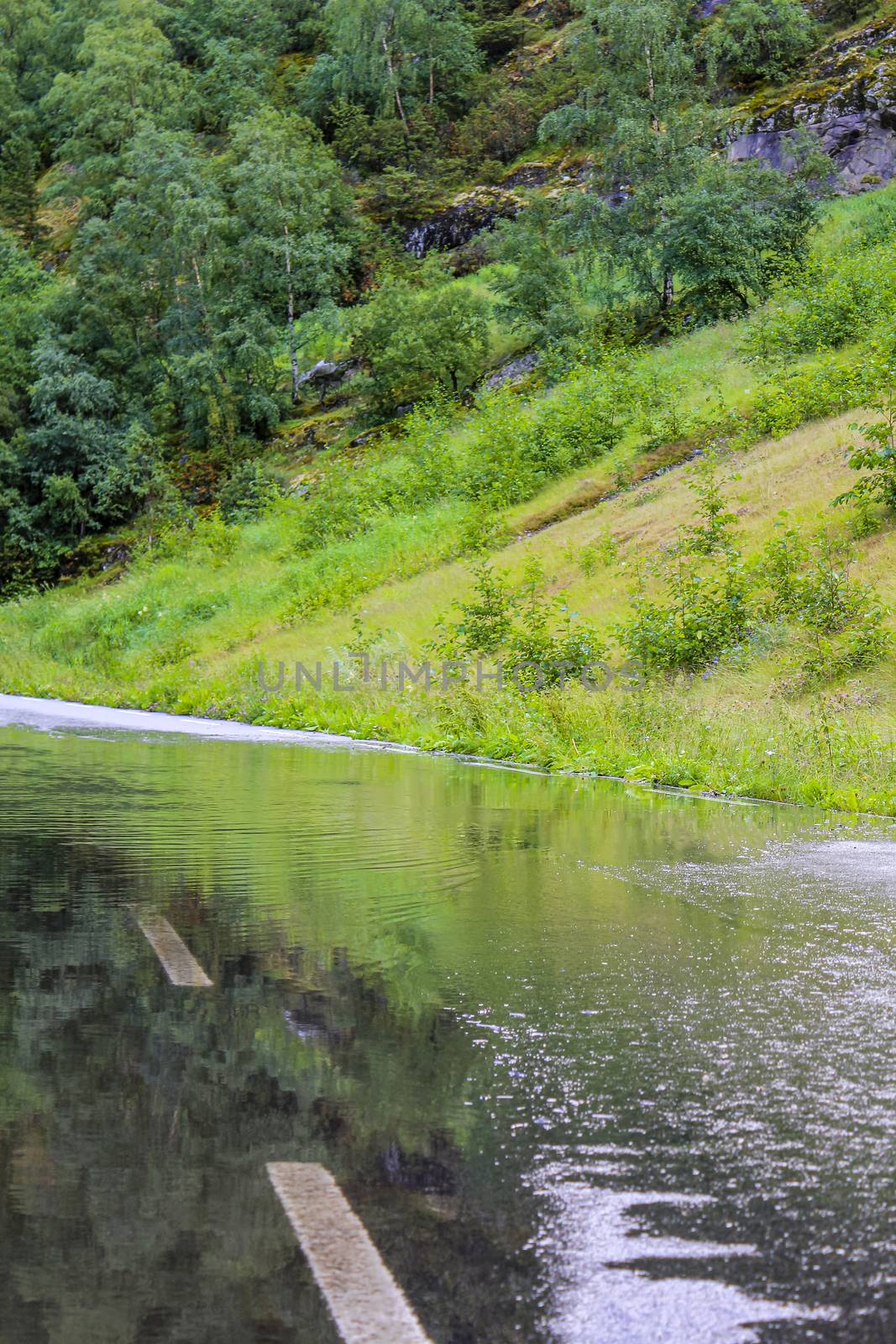 Big puddle on the road after rain. Wet road in Hemsedal, Viken, Norway.