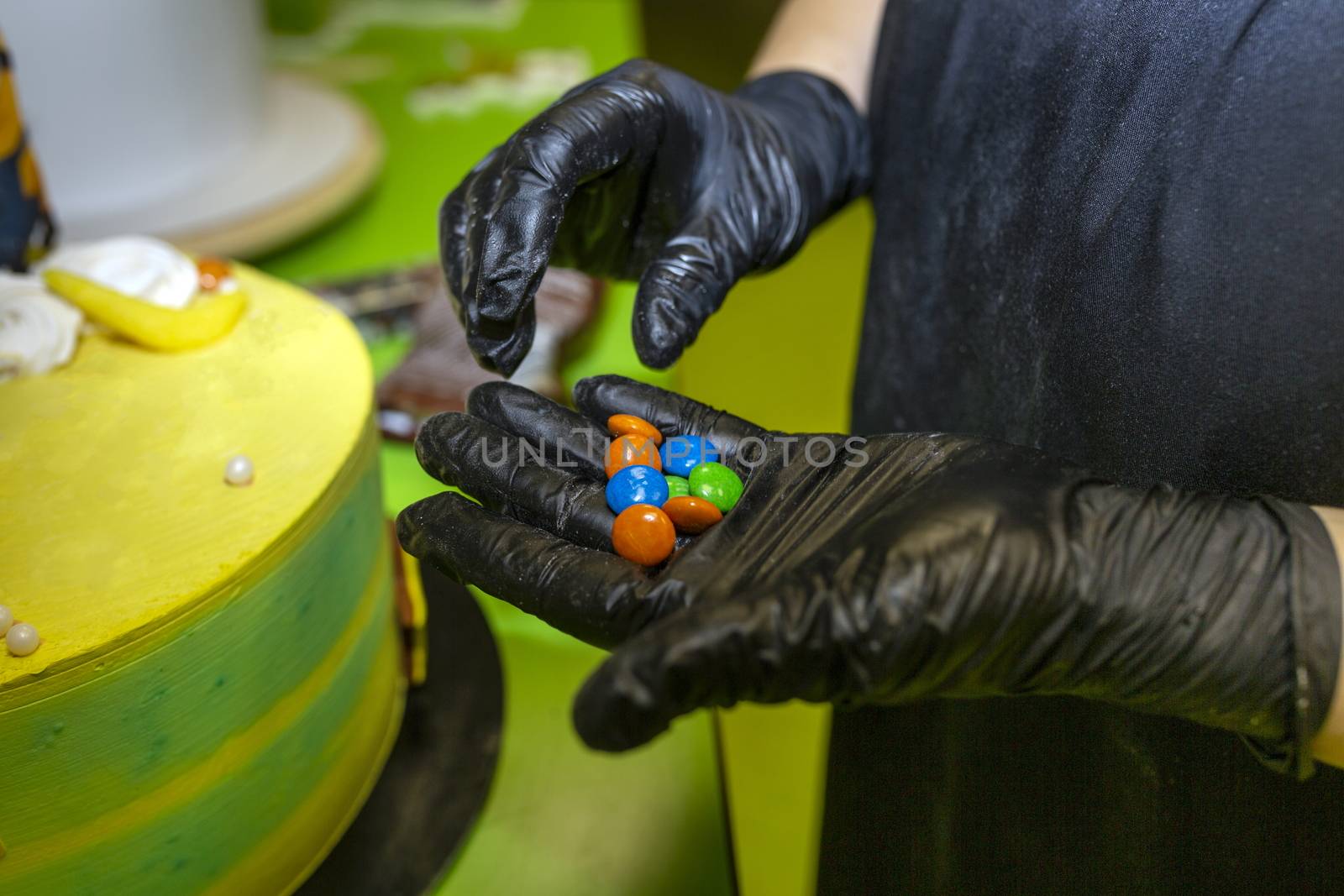 Cake cooking. The chef decorates the mold for the preparation of a round cake. Colorful decorations, sea pebbles