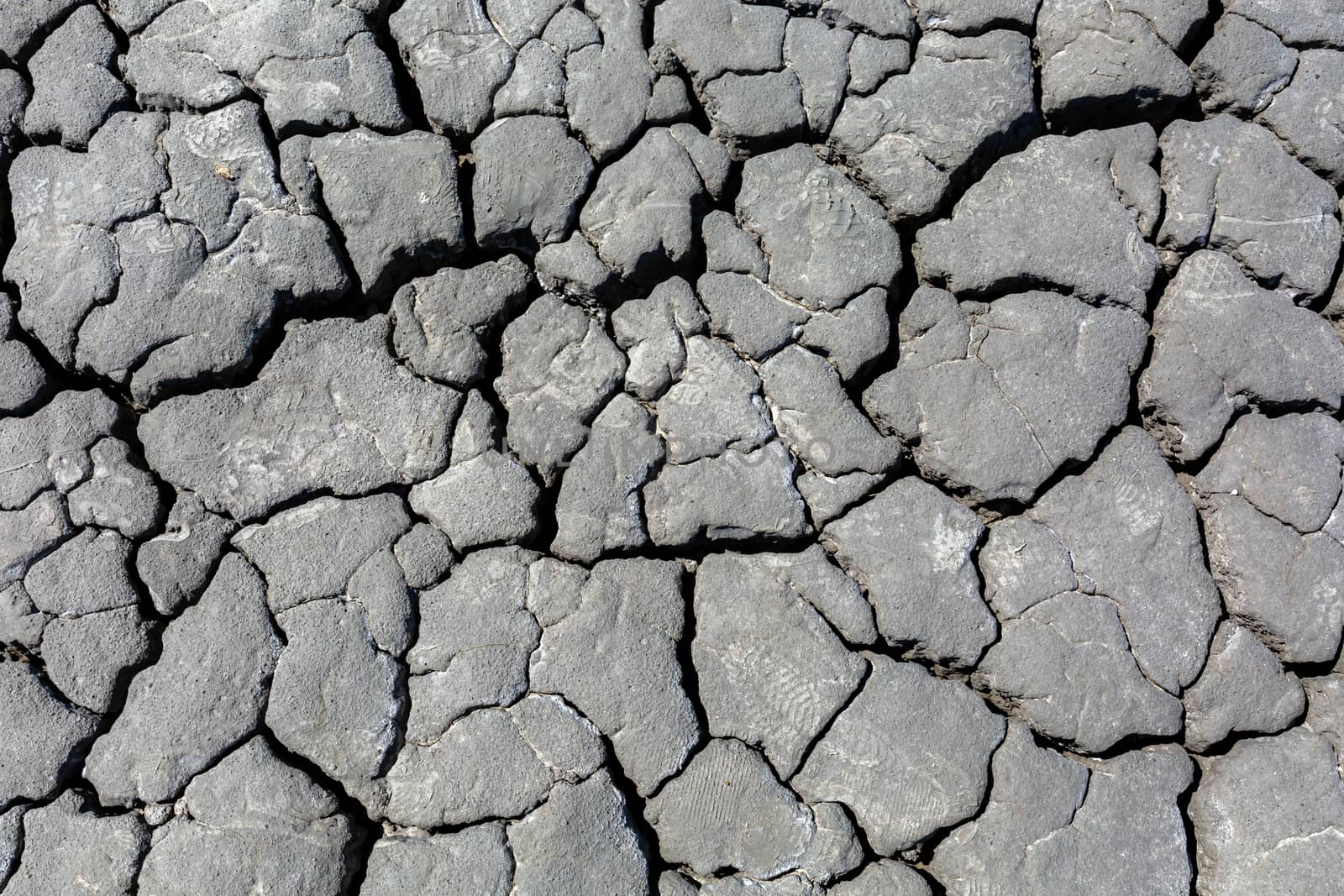 Drought, dried cracked earth. Cracks in the clay. Water shortage problem. The heat of distress is hunger. Background texture corrosion of the earth Gray color