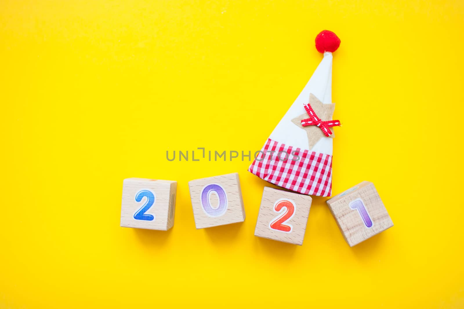 Happy New year 2021 celebration. The inscription 2021 from children's educational wooden cubes on a bright yellow background