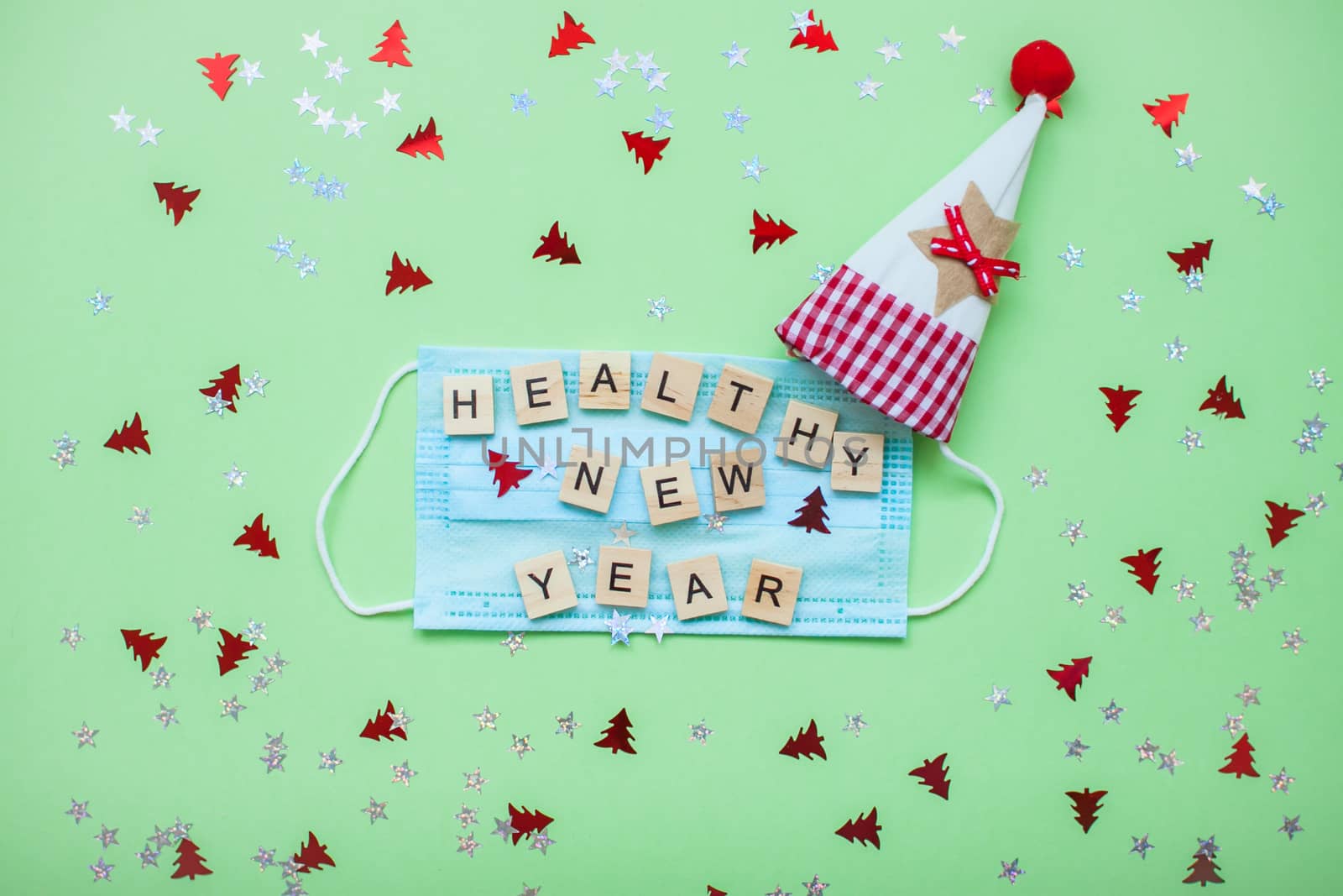 inscription from wooden blocks of a healthy new year on a medical protective mask and on a new year background