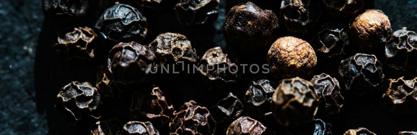 Black pepper closeup on luxury stone background as flat lay, dry food spices and recipe ingredient by Anneleven