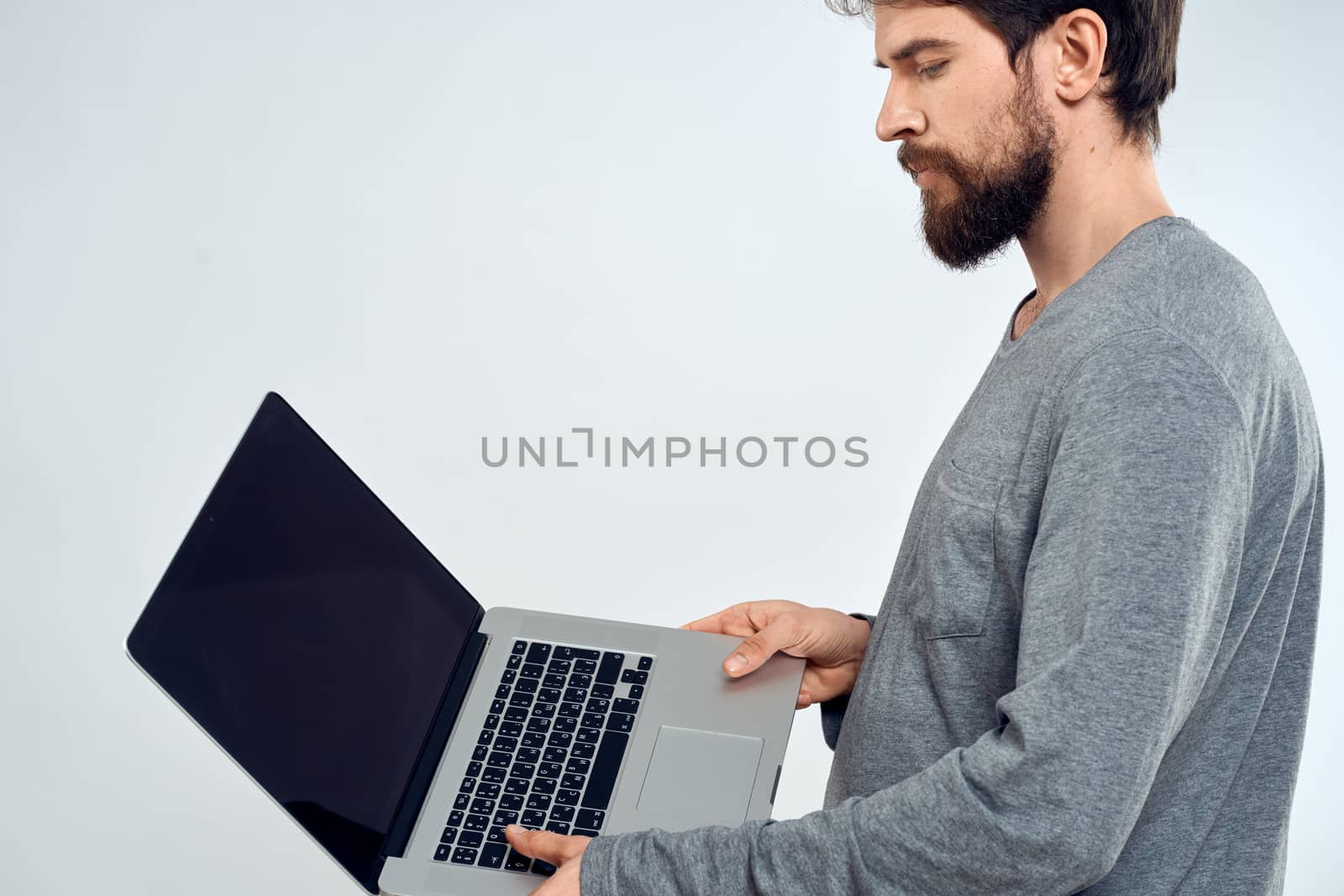 A man in a gray sweater with a laptop hands lifestyle technology communication internet work. High quality photo