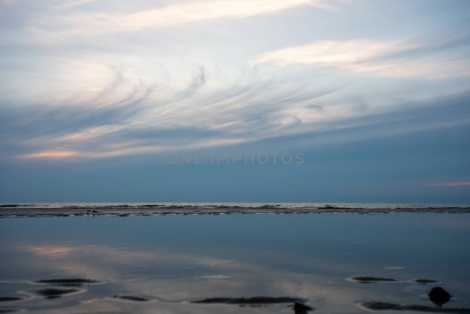 An Abstract Shot of A Whispy Sunset Sky Mirrored in a Pool of Water