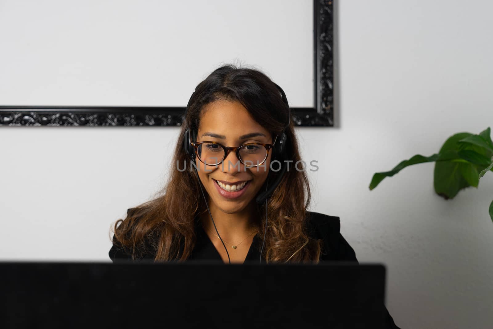 Portrait of beautiful young afro american woman working from home online with headphones