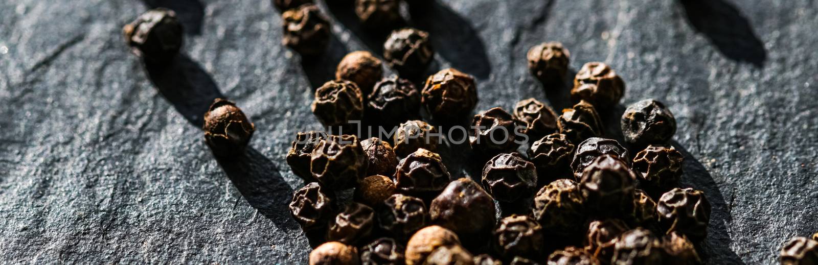 Black pepper closeup on luxury stone background as flat lay, dry food spices and recipe ingredients