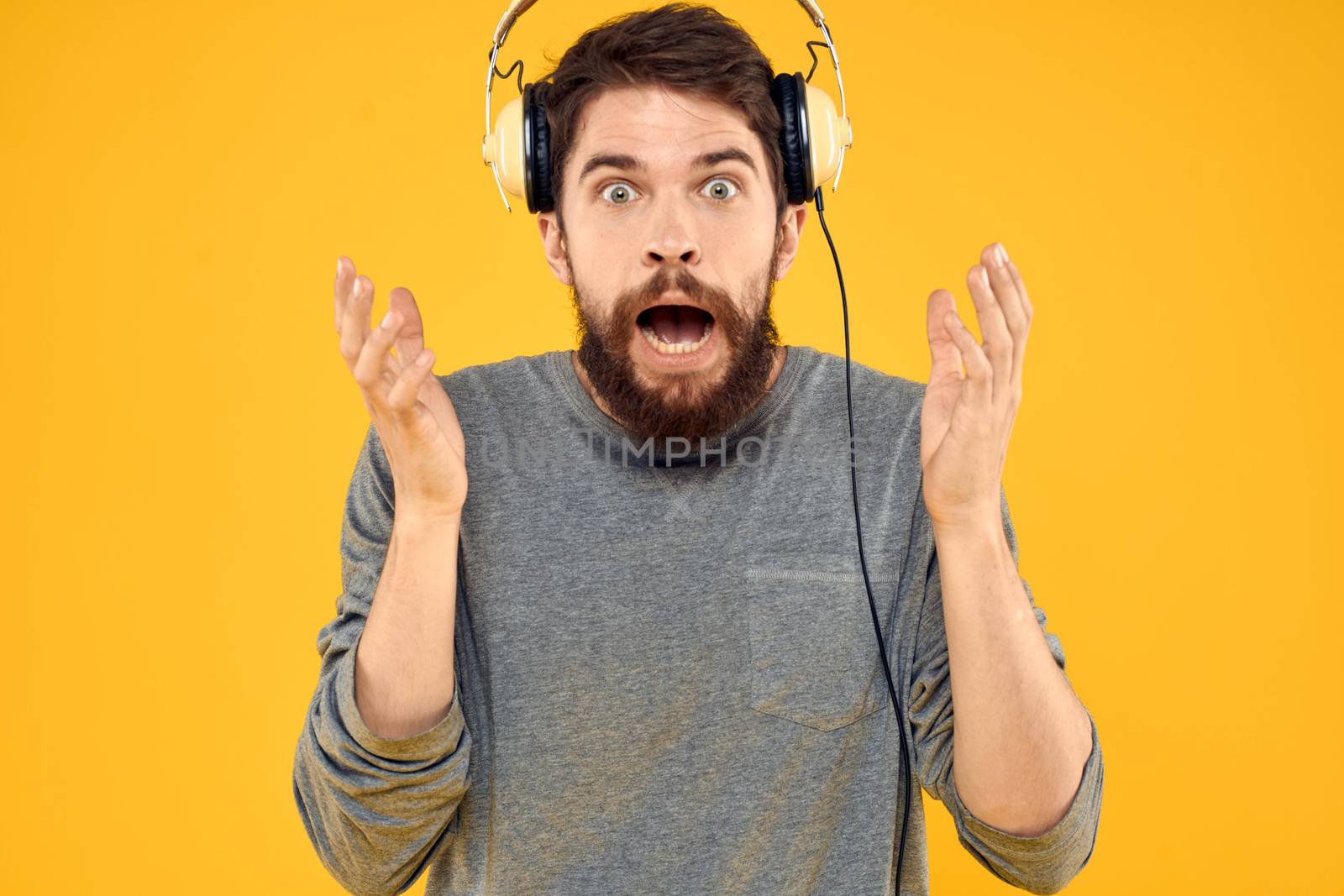 Man in headphones listens to music technology lifestyle fun people yellow background. High quality photo