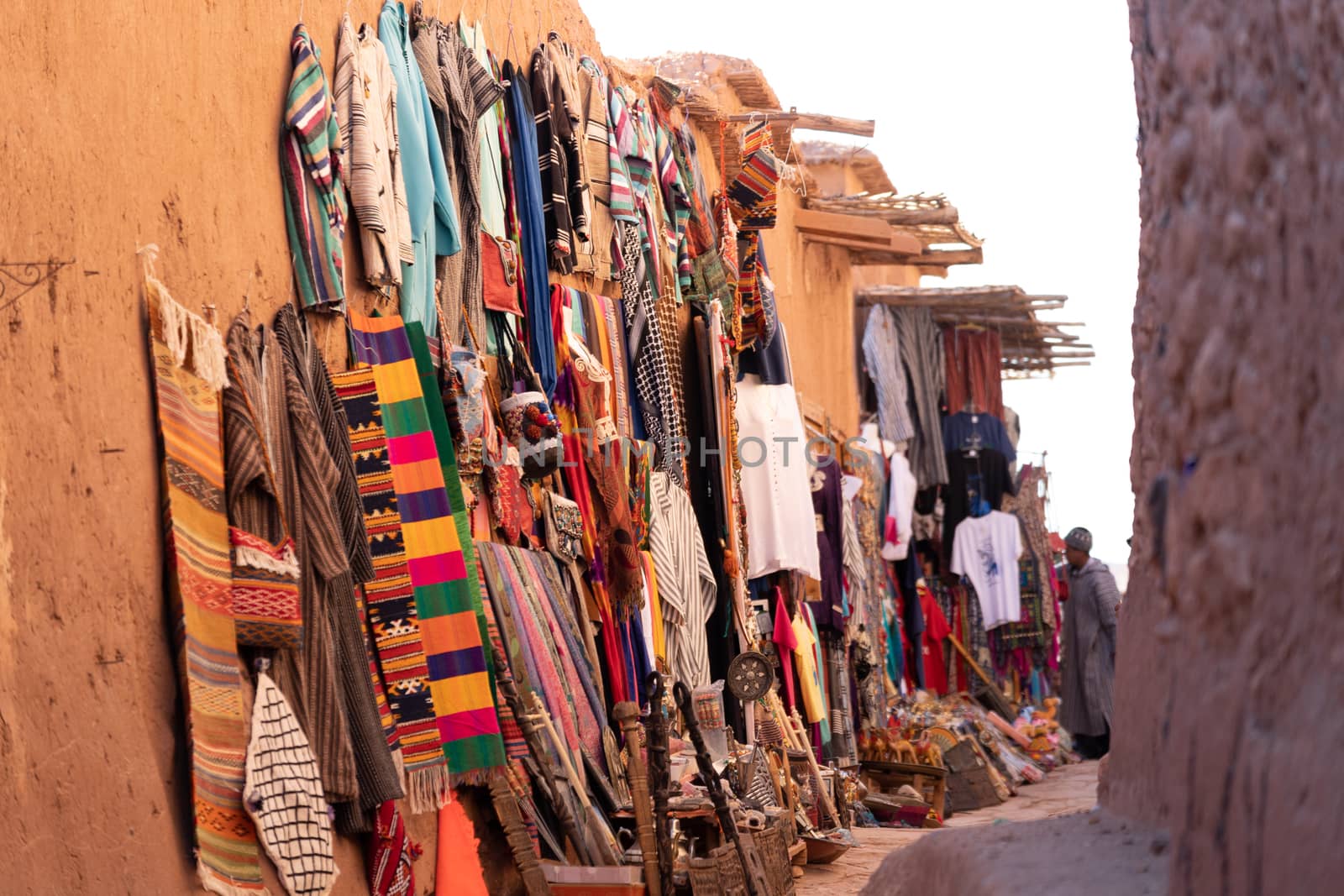 Tourist shop selling mementoes of Ait Ben Haddou ksar Morocco, ancient fortress that is a Unesco Heritage site. Beautiful late afternoon light with honey, gold coloured mud brick construction the kasbah, or fortified town dates from 11th cent. and is on the former caravan route from the Sahara and Marrakech. The location has been used for many famous movies. High quality photo