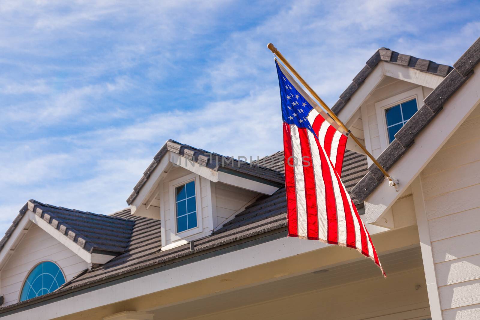 American Flag Hanging From House Facade.