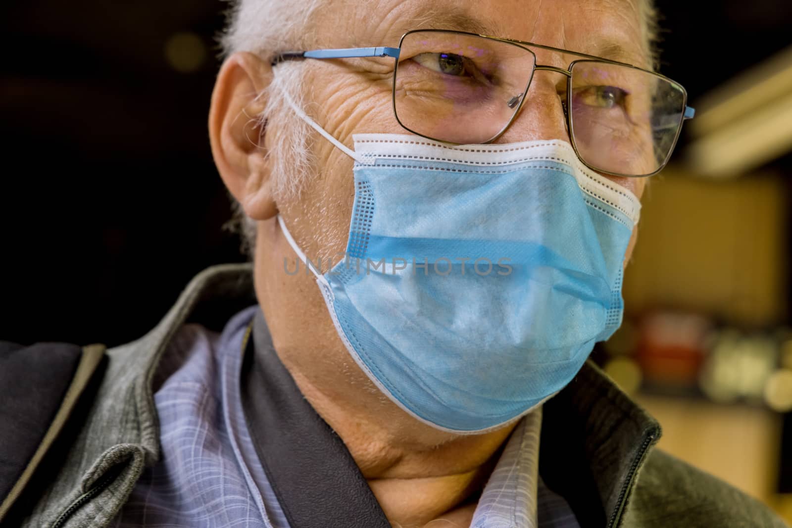 Safety in a public place while epidemic mature man wearing disposable medical face mask of the subway in New York during coronavirus outbreak covid-19 by ungvar