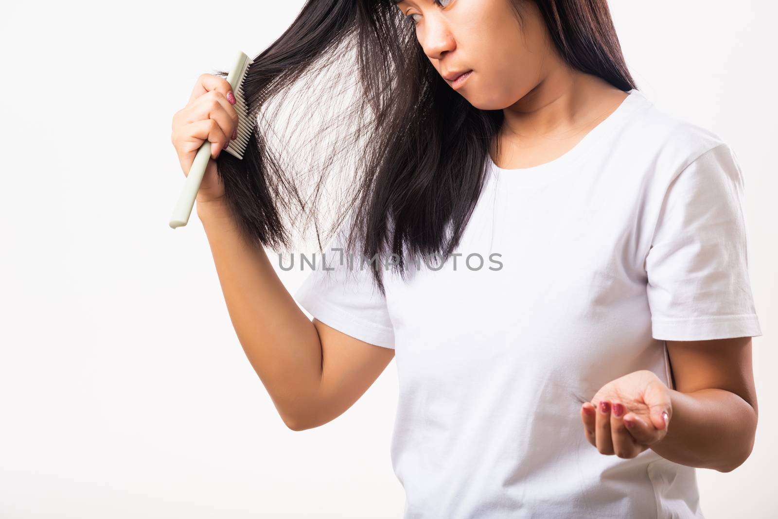 Asian woman weak hair problem her use comb hairbrush brush her hair and showing damaged long loss hair from the brush on hand, studio shot isolated on white background, Medicine health care concept