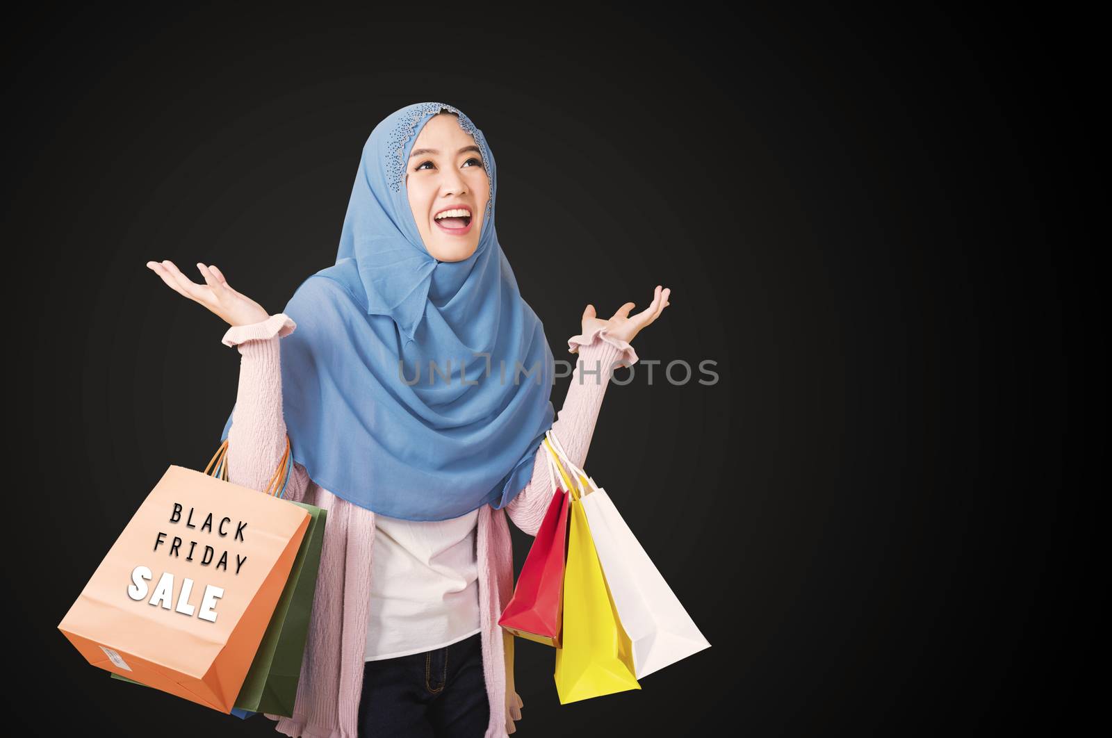 Happy beautiful young woman Muslim smiling funny wear veil hijab she excited holding shopping bags multi color, isolated on black background with copy space, Black Friday sale concept