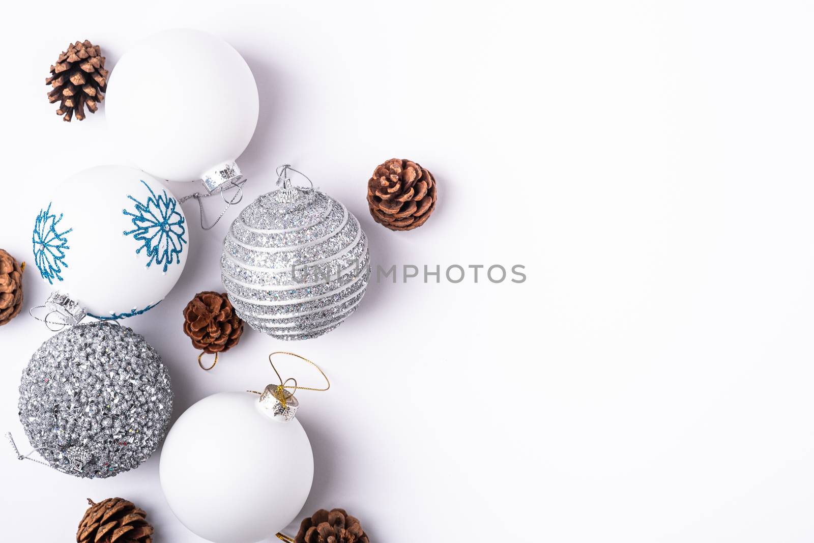 Christmas New Year composition. Gifts, fir tree cones, silver ball decorations on white background. Winter holidays concept. Flat lay, top view, copy space