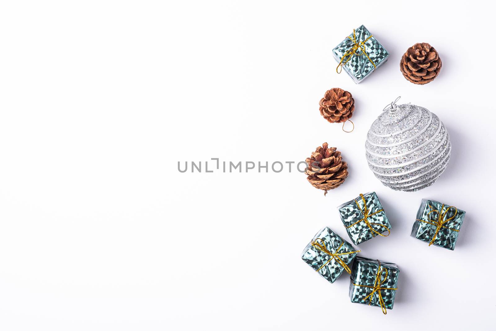 Christmas New Year composition. Gifts, fir tree cones, silver ball decorations on white background. Winter holidays concept. Flat lay, top view, copy space