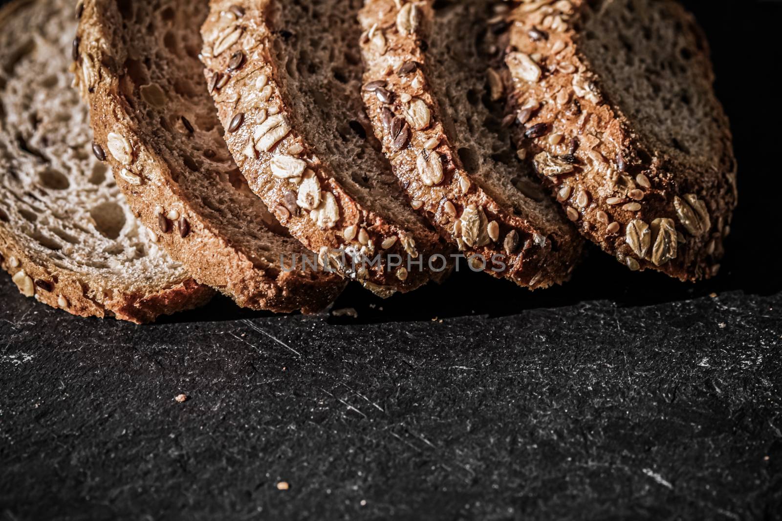 Fresh whole grain seeded bread, organic wheat flour, closeup slice texture as background for food blog or cook book recipes