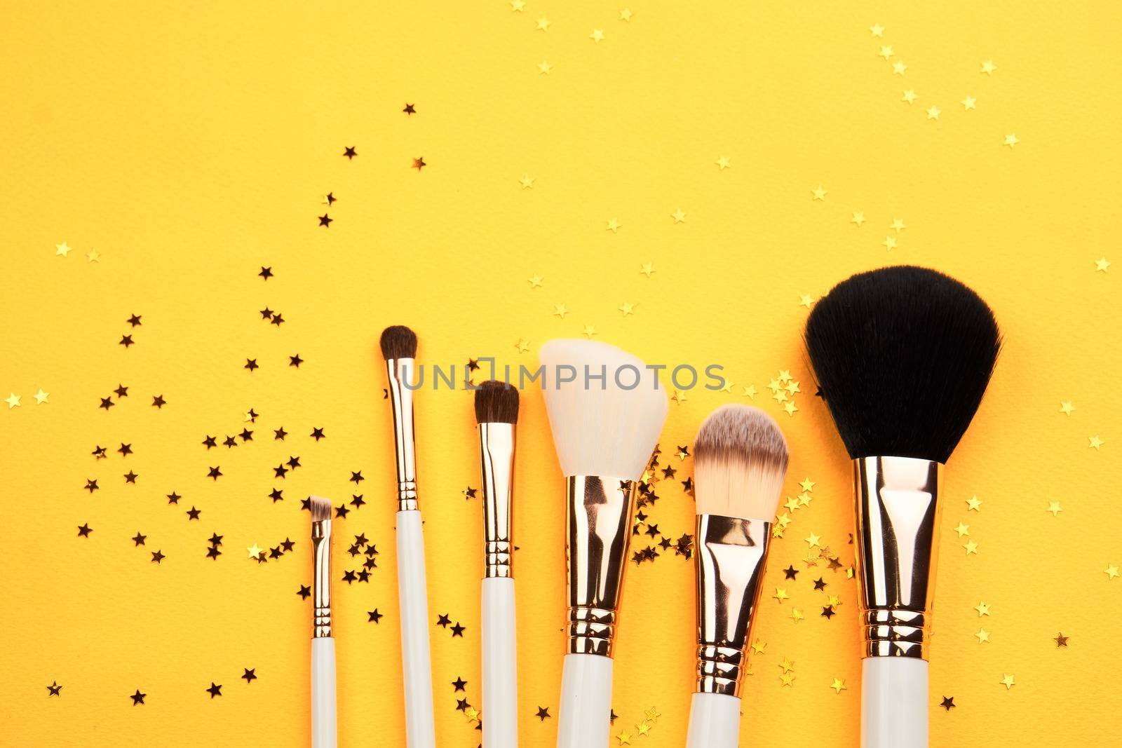 Makeup brushes in different sizes on a yellow background and glitter cropped look by SHOTPRIME