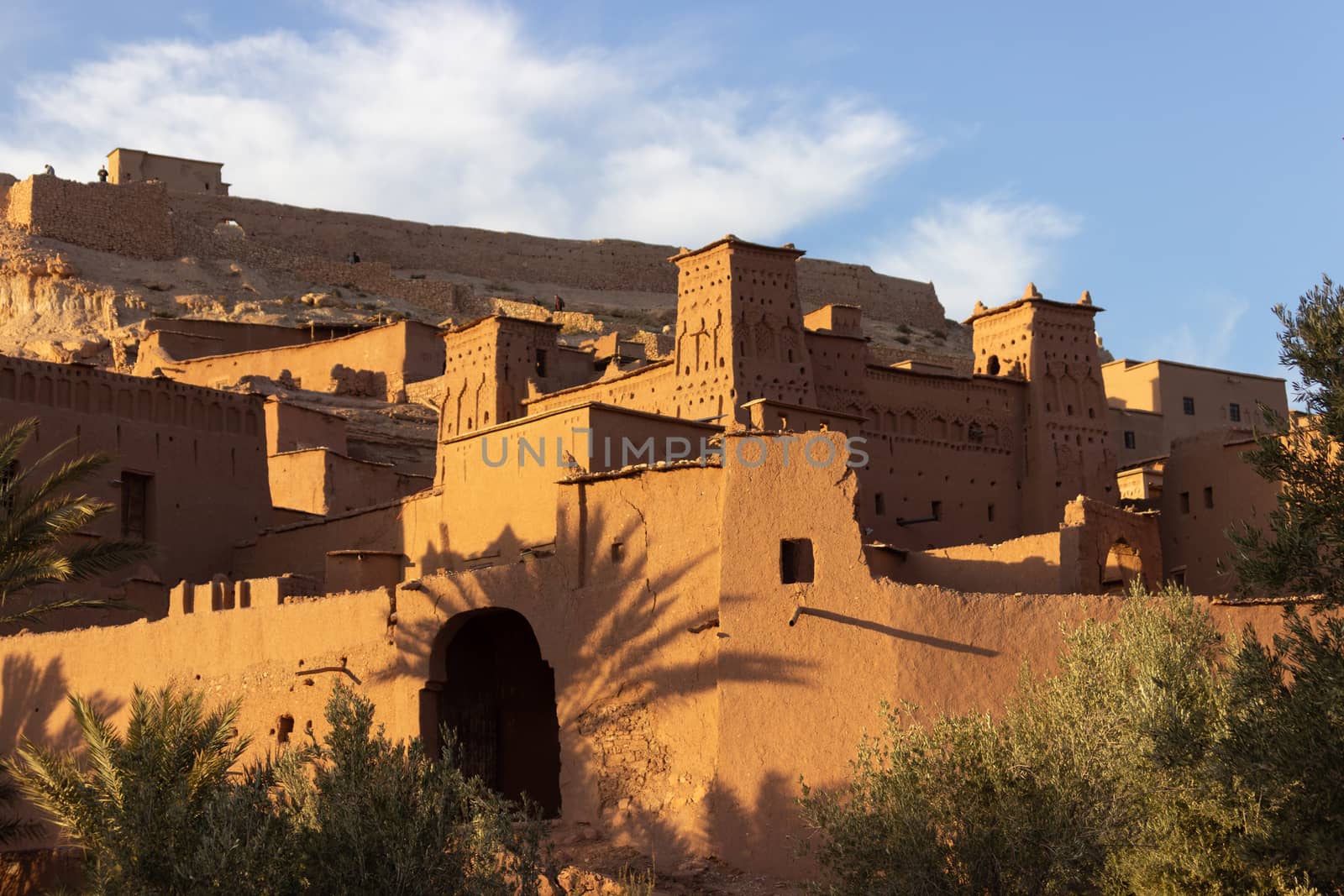 Ait Ben Haddou ksar Morocco, ancient fortress that is a Unesco Heritage site. Beautiful late afternoon light with honey, gold coloured mud brick construction the kasbah, or fortified town dates from 11th cent. and is on the former caravan route from the Sahara and Marrakech. The location has been used for many famous movies. High quality photo