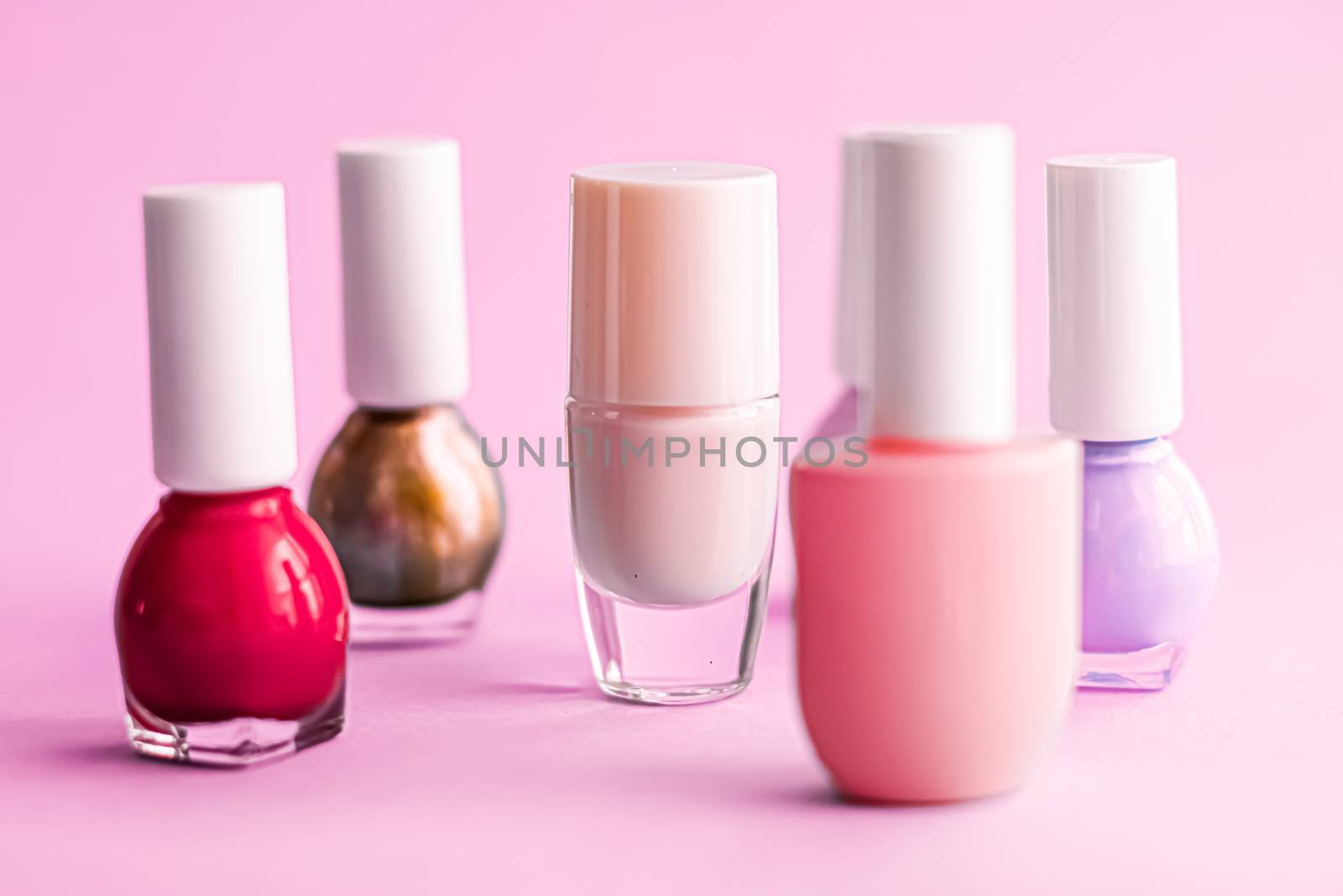 Nail polish bottles on pink background, beauty branding