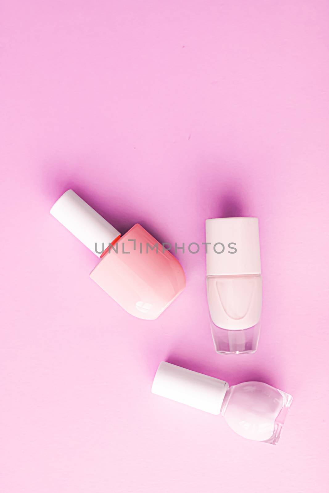 Nail polish bottles on pink background, beauty branding