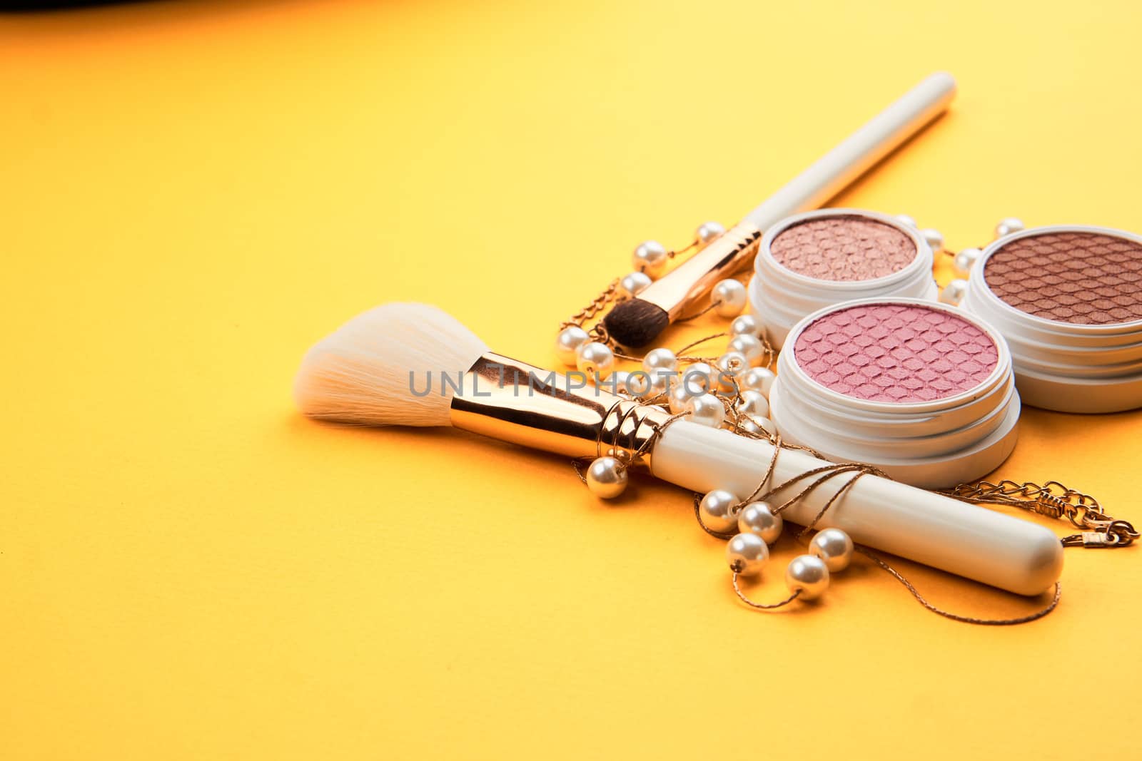 Eyeshadow eye makeup brush on yellow background top view Copy Space by SHOTPRIME