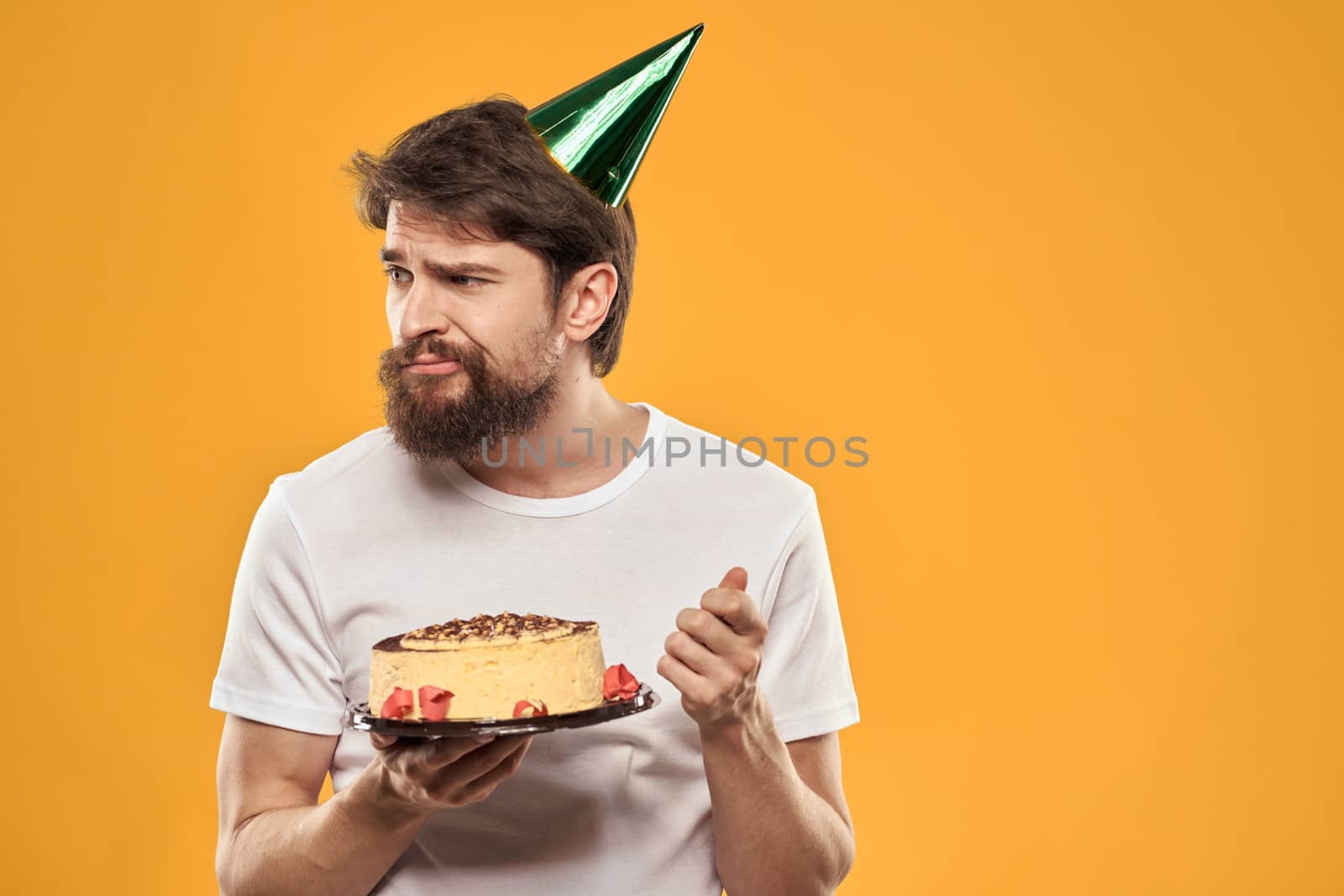 birthday boy in a cap with cake fun yellow background party by SHOTPRIME