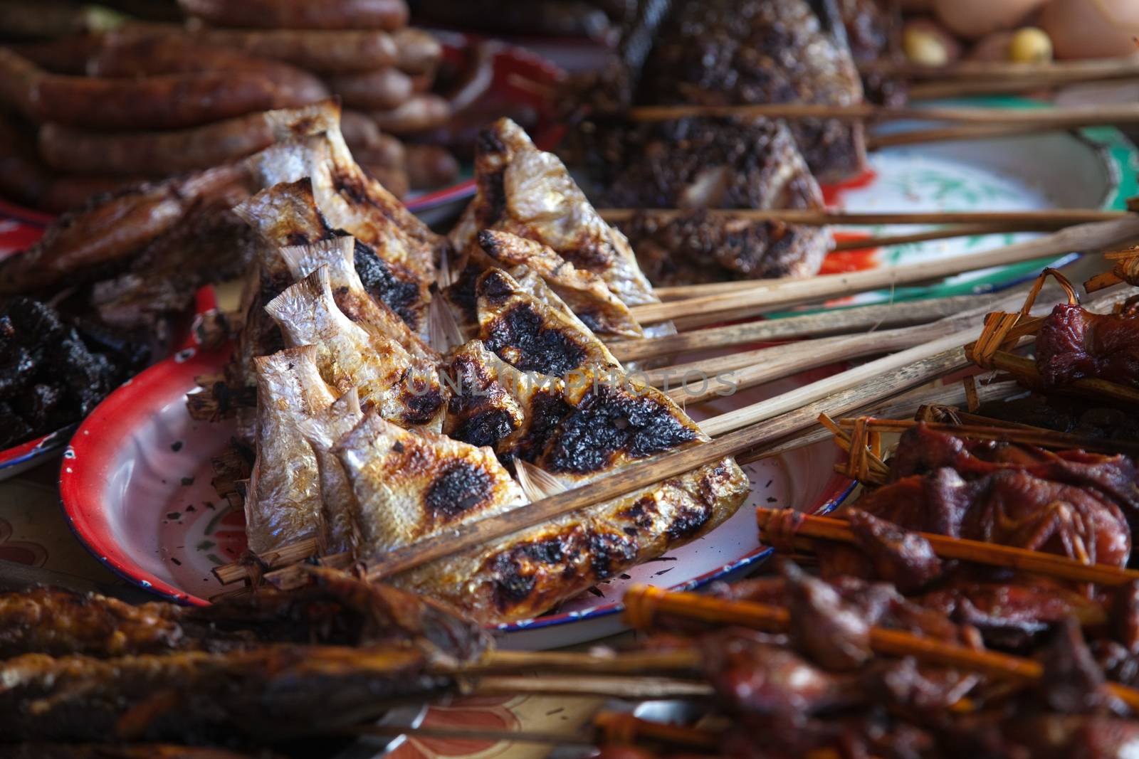 Laos, street food. Traditional food cooked at road sides in stalls on skewers for grilling, chicken, fish, birds High quality photo