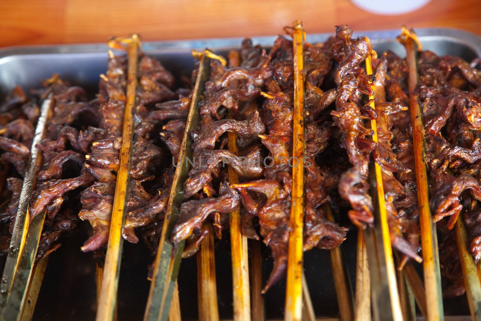 Laos, street food. Traditional food cooked at road sides in stalls on skewers for grilling, chicken, fish, birds High quality photo