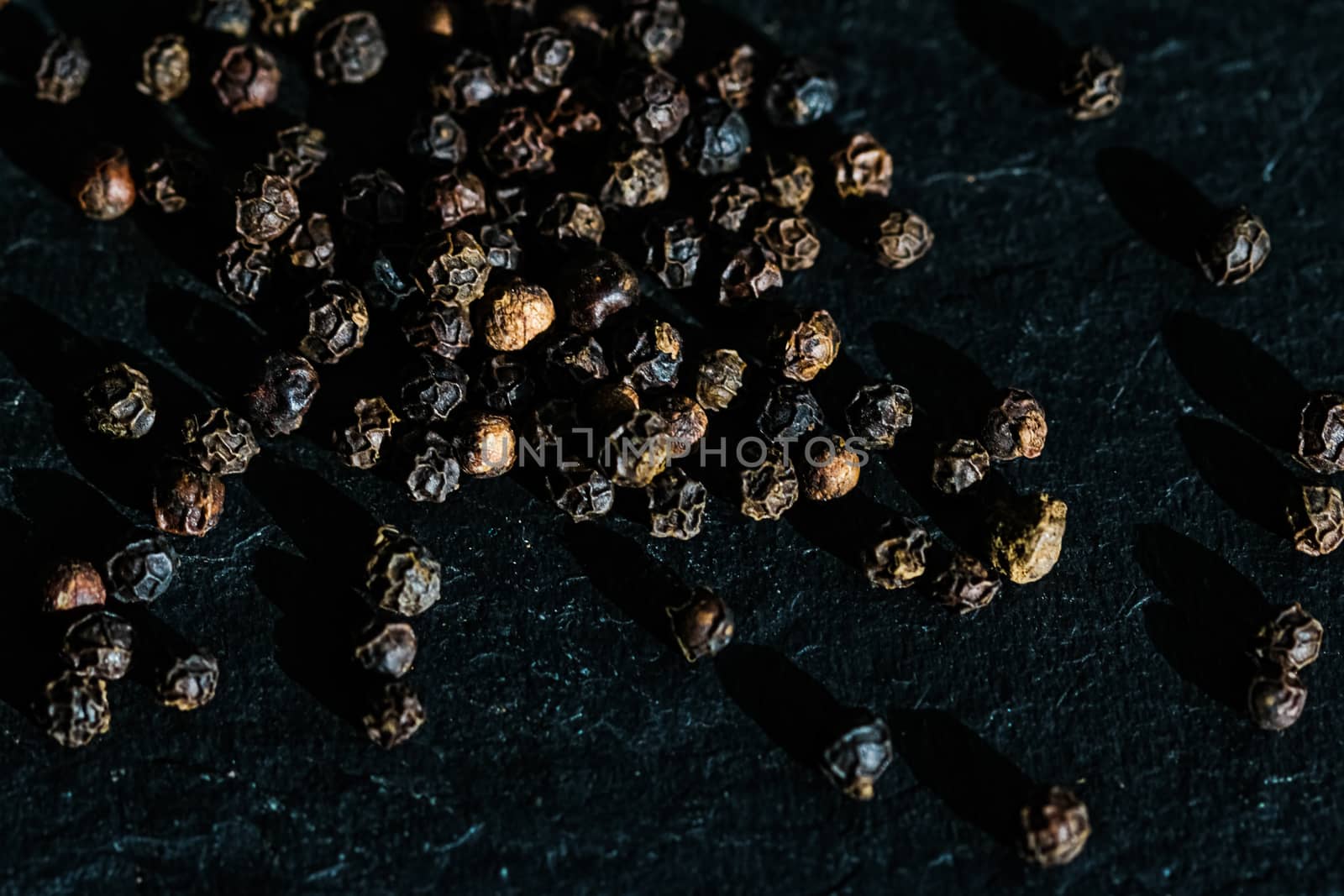 Black pepper closeup on luxury stone background as flat lay, dry food spices and recipe ingredients