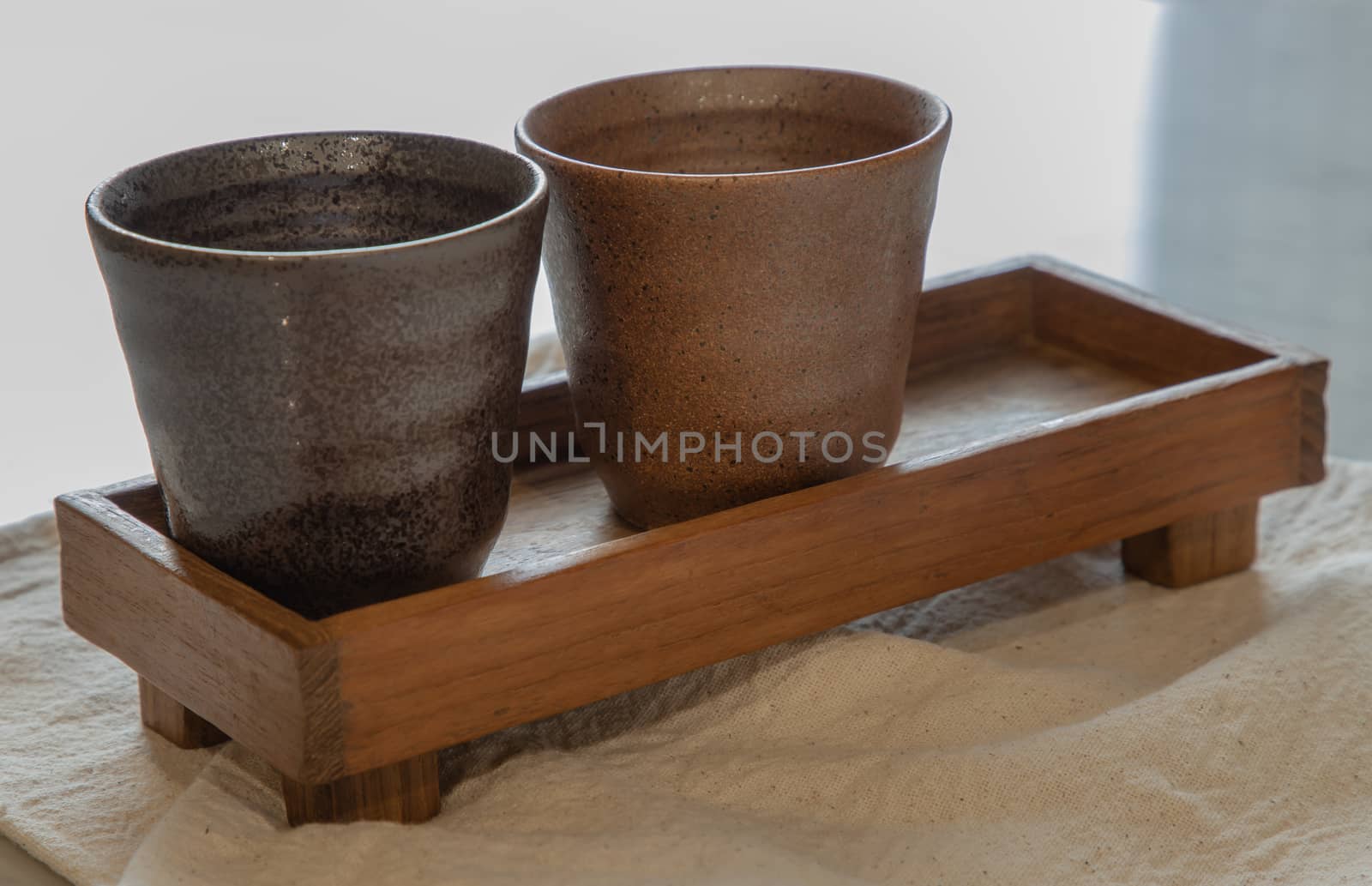 Two ceramics mugs handmade on marble table of living room. Home decor. Space for text. No focus, specifically.