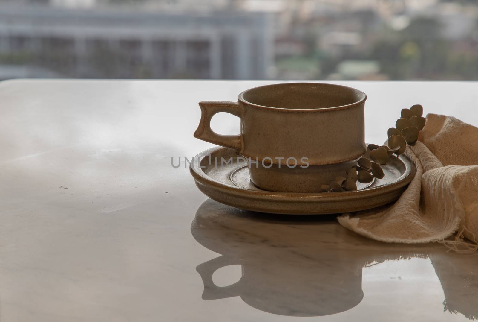 Ceramic mug handmade with Dried flower on marble table of living room and city view. Home decor. Space for text. Selective focus.