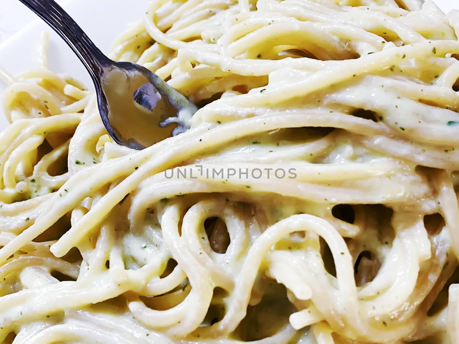 A fork in a plate of creamy spaghetti. by rarrarorro