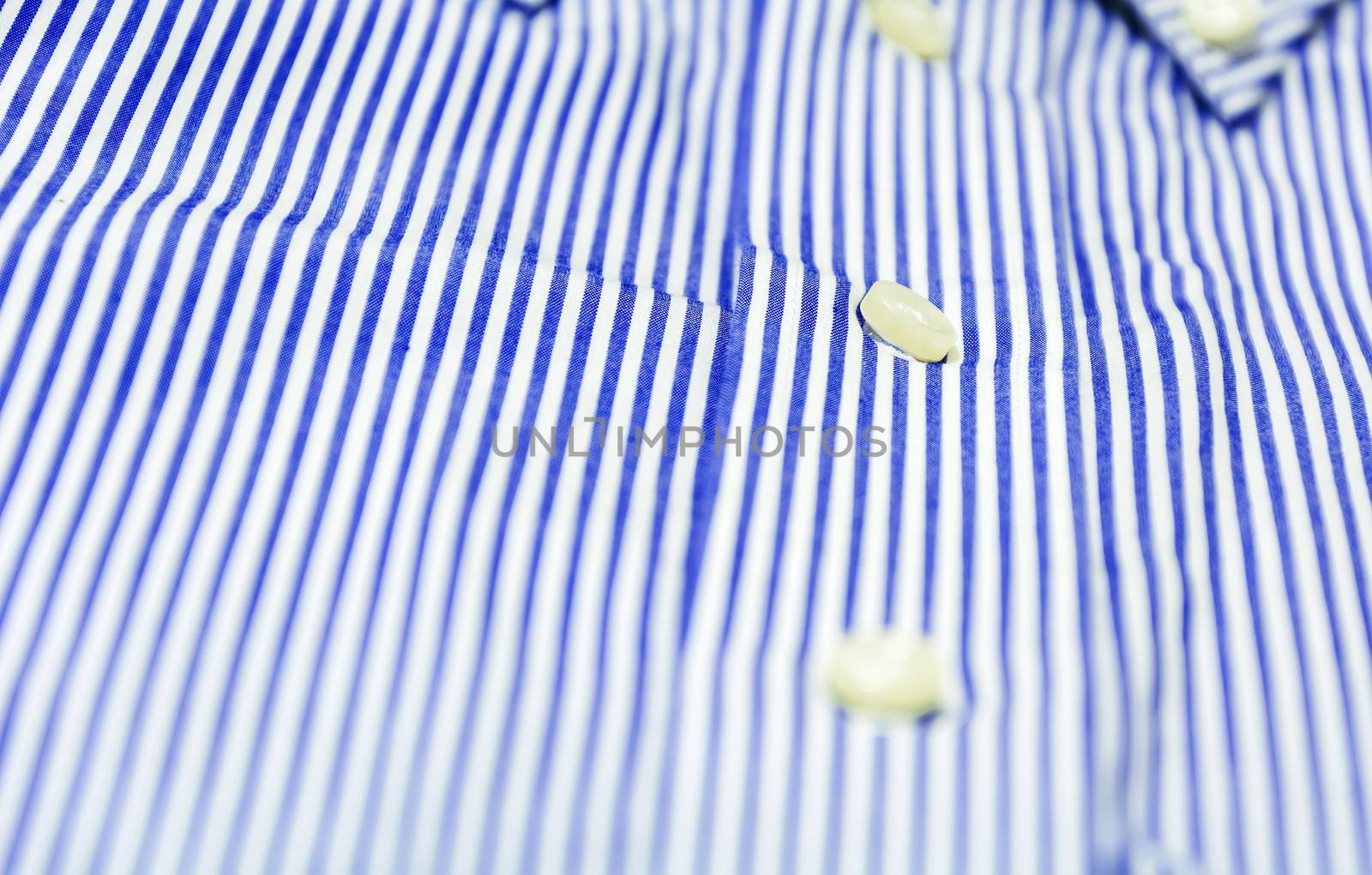 The button of a blue striped shirt with a button down collar. Formal wear for events or work and business meetings