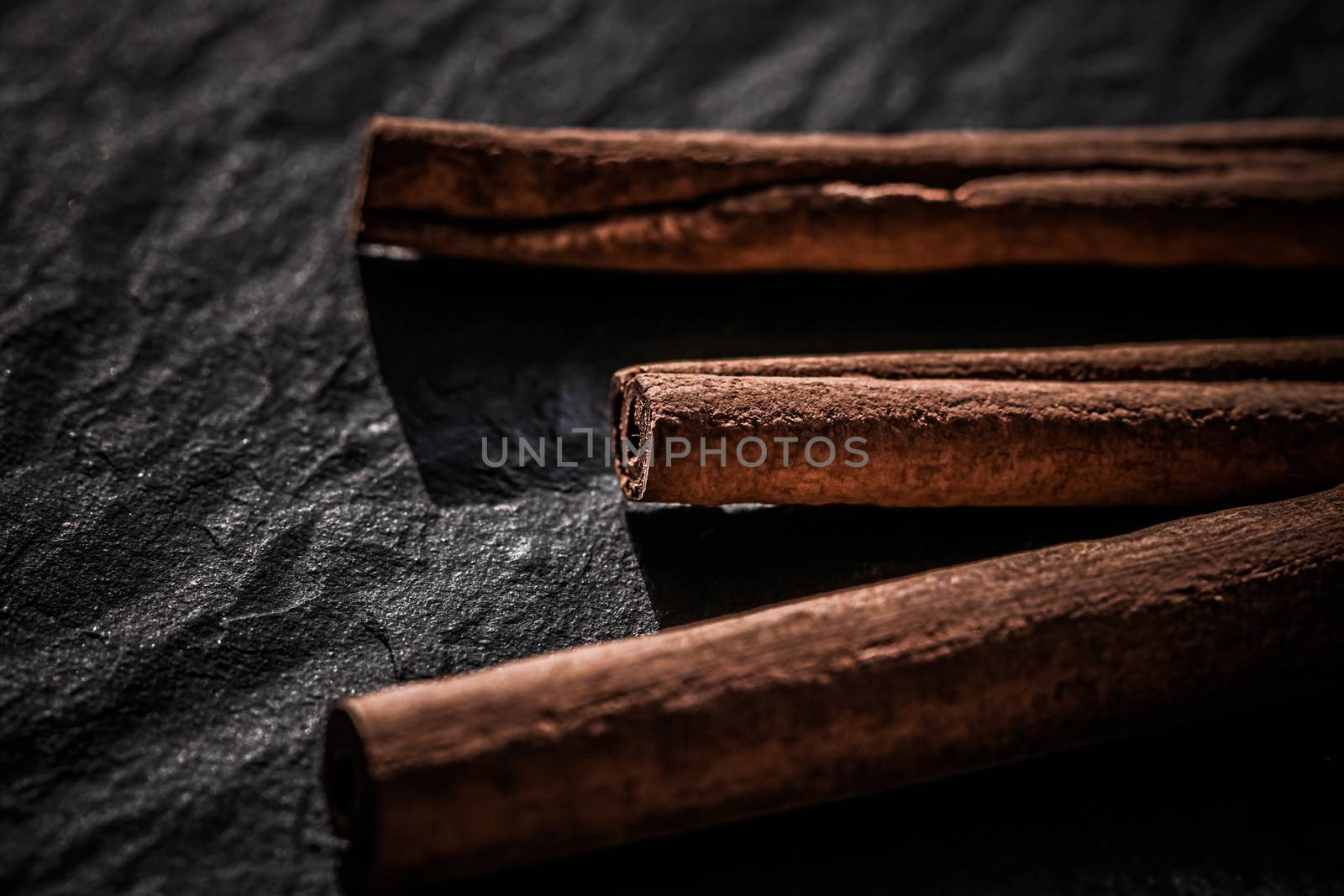 Cinnamon sticks on black stone background, food recipes