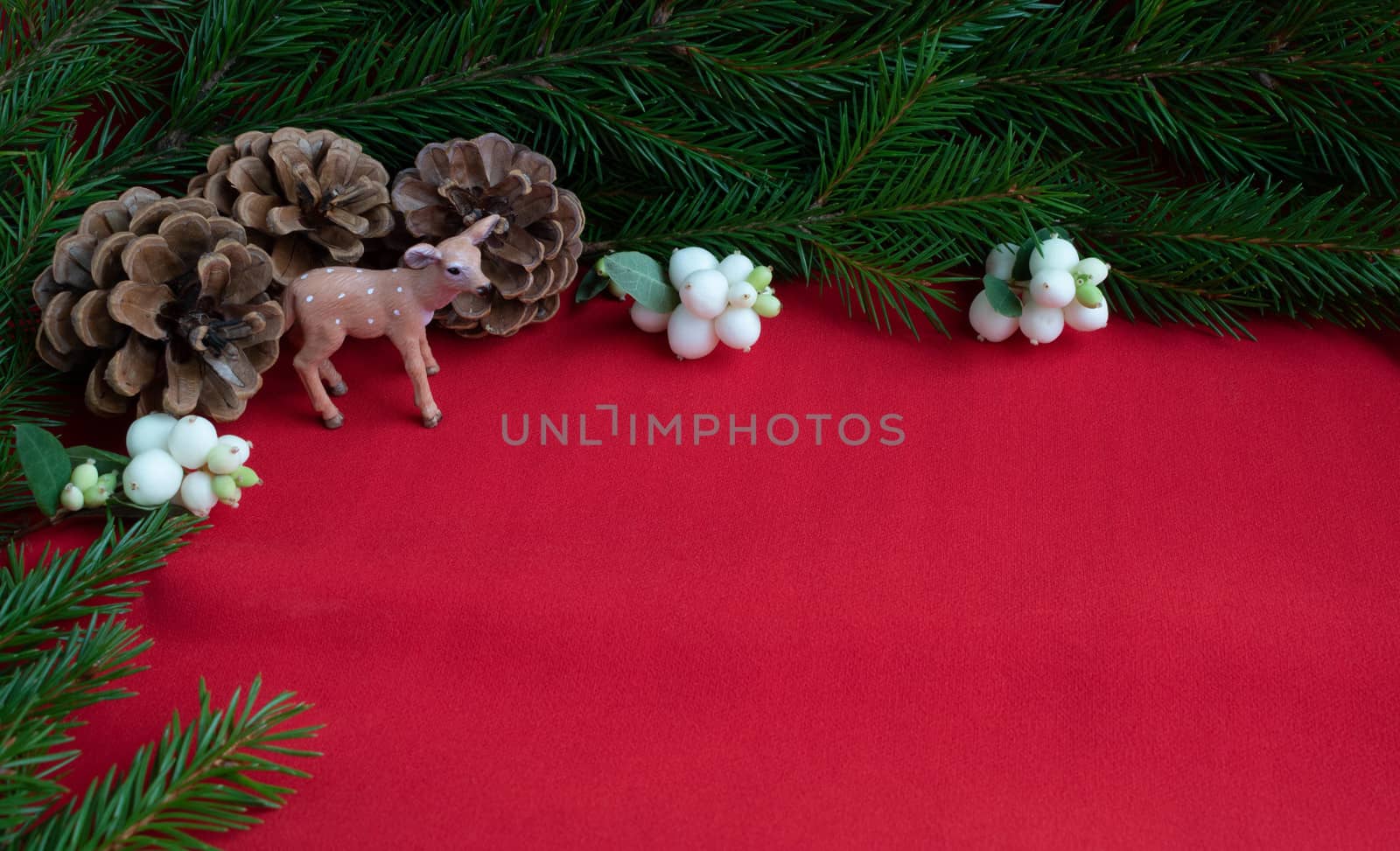 Three pine cones,a deer and spruce branches with white berries . The concept of New year and Christmas. Space for your text.