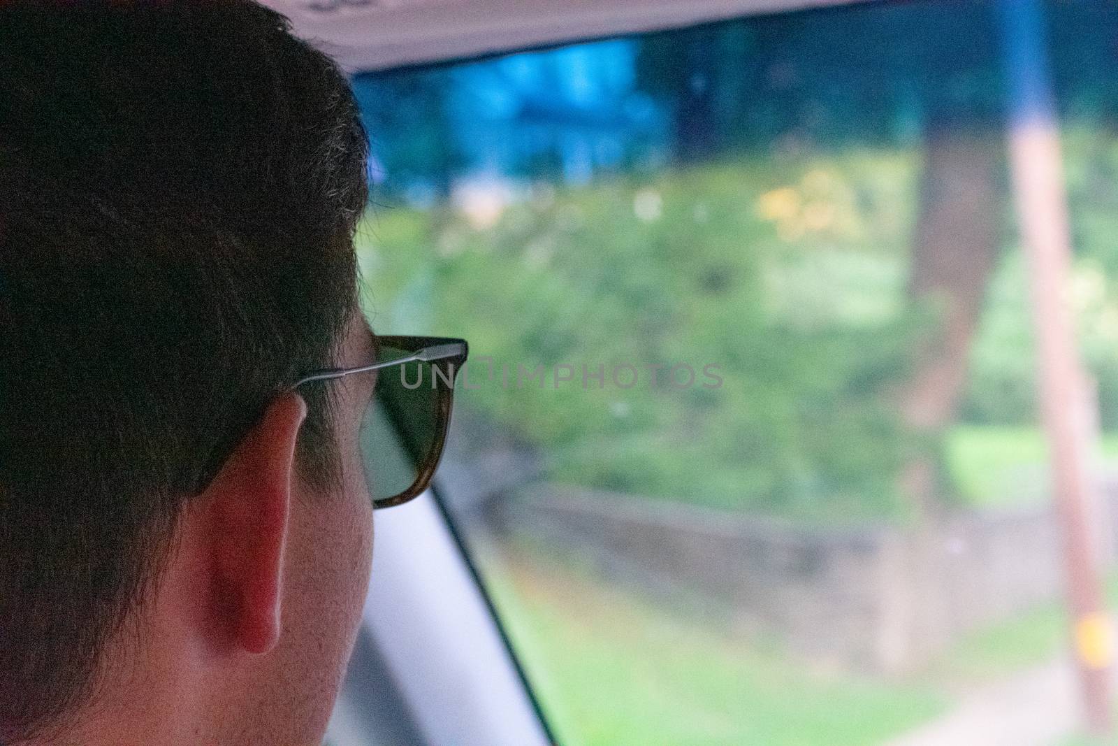 A Caucasian Man Wearing Sunglasses Focused on the Road While Dri by bju12290