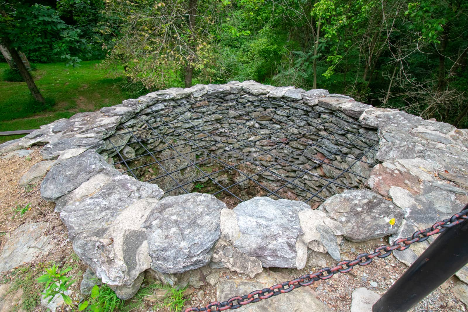 A Large Hole With Cobblestone Walls and a Metal Covering Over the Top at the Historic Lock 12 in Pennsylvania