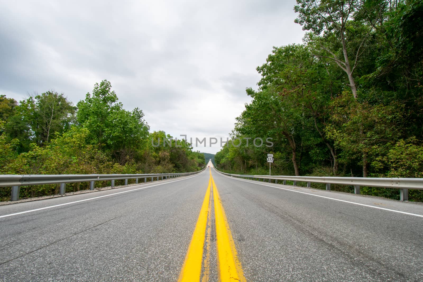 A Shot From the Center of a Road With a Large Long Bridge Up Ahe by bju12290