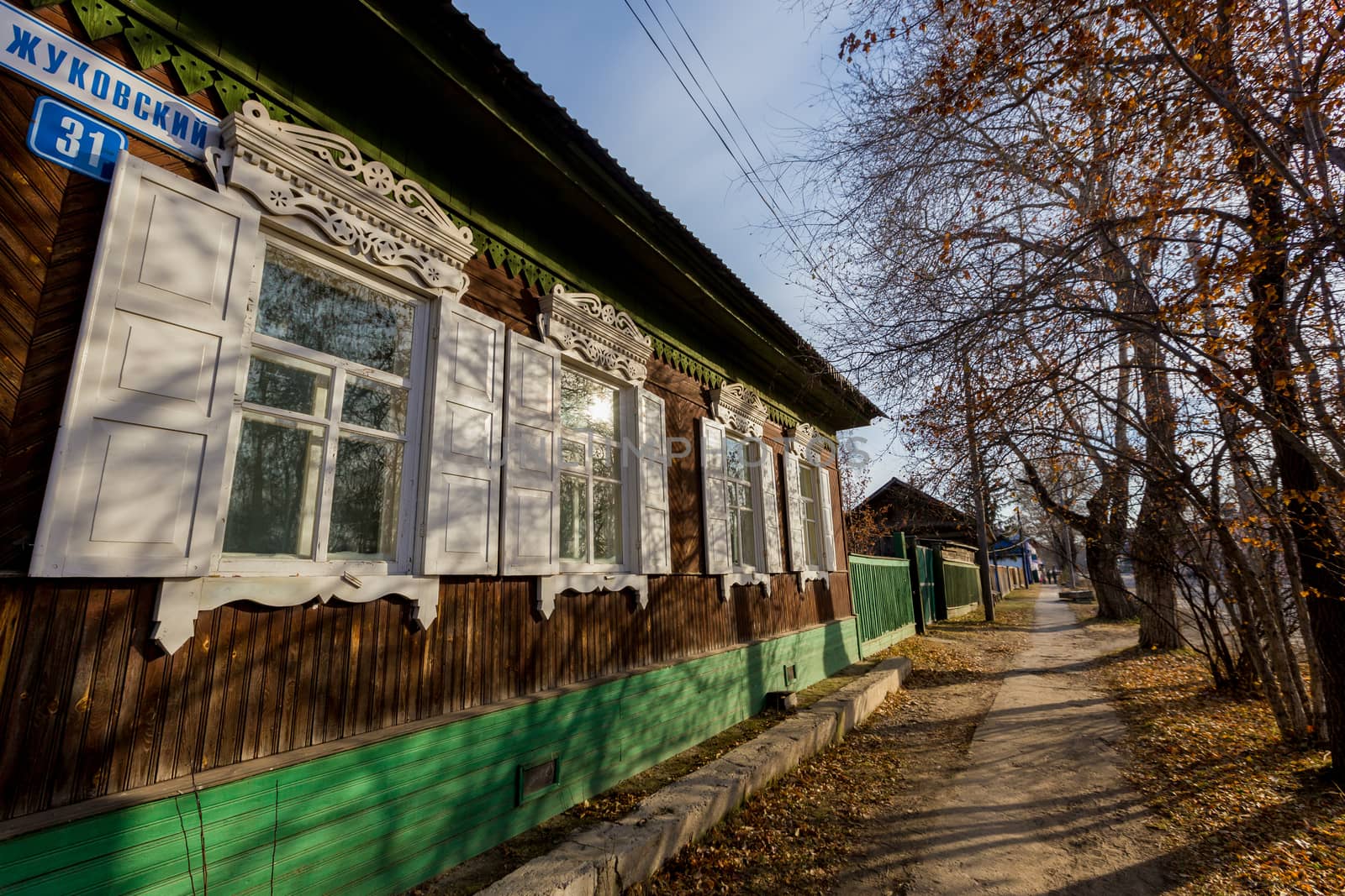 An old one-story wooden house with carved shutters in the Russian style.